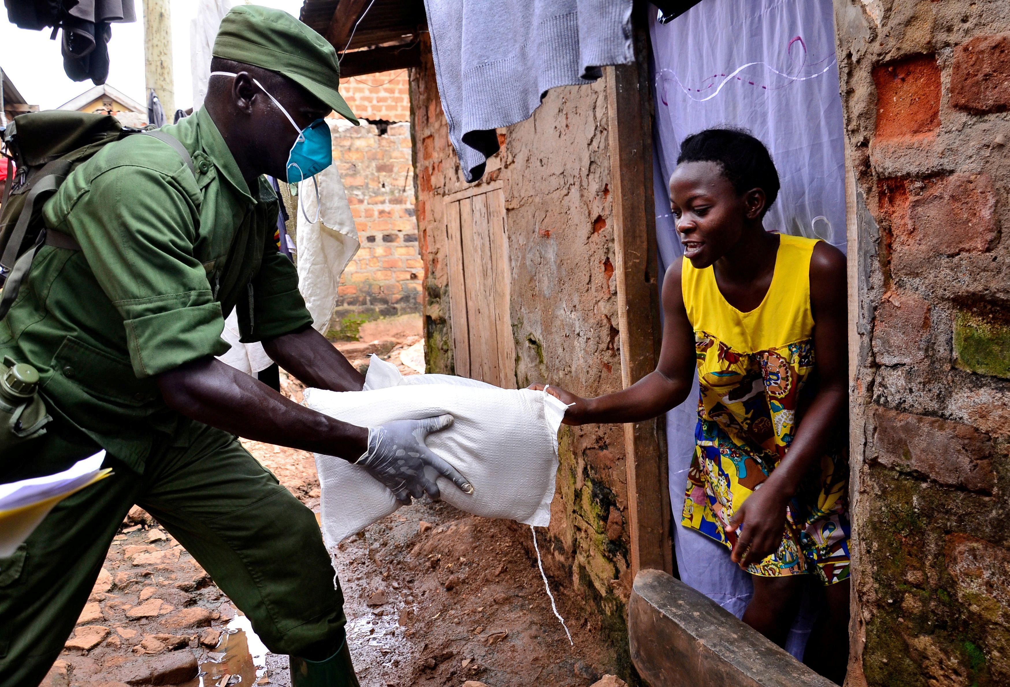 A civilian receives relief food during a government distribution exercise to civilians affected by the lockdown, as part of measures to prevent the potential spread of coronavirus disease (COVID-19), in Kampala, Uganda April 4, 2020. REUTERS/Abubaker Lubowa/File Photo