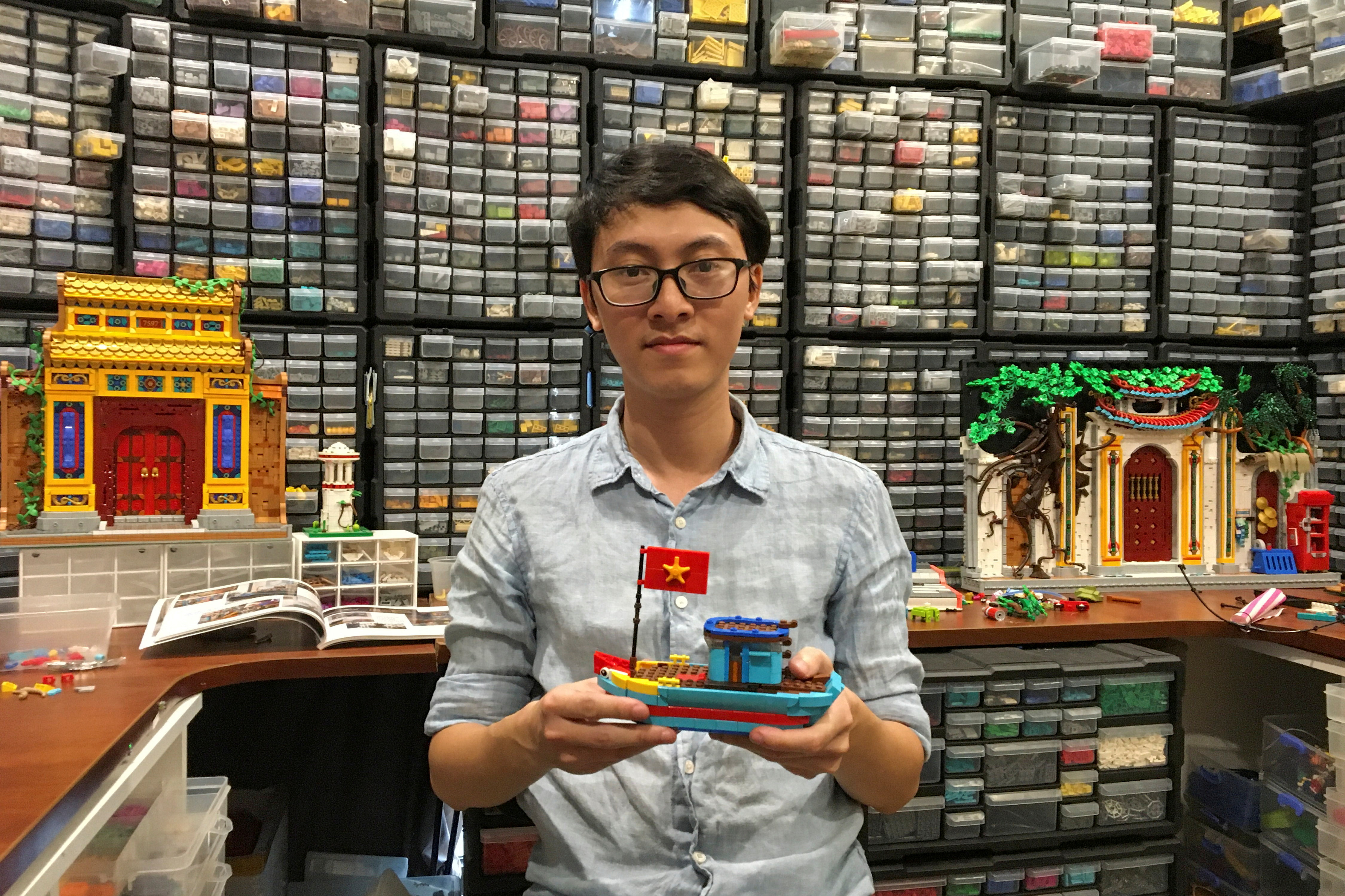 Hoang Dang, an industrial designer who loves Lego since he was a child poses in front of his pieces at his home in Hanoi, Vietnam