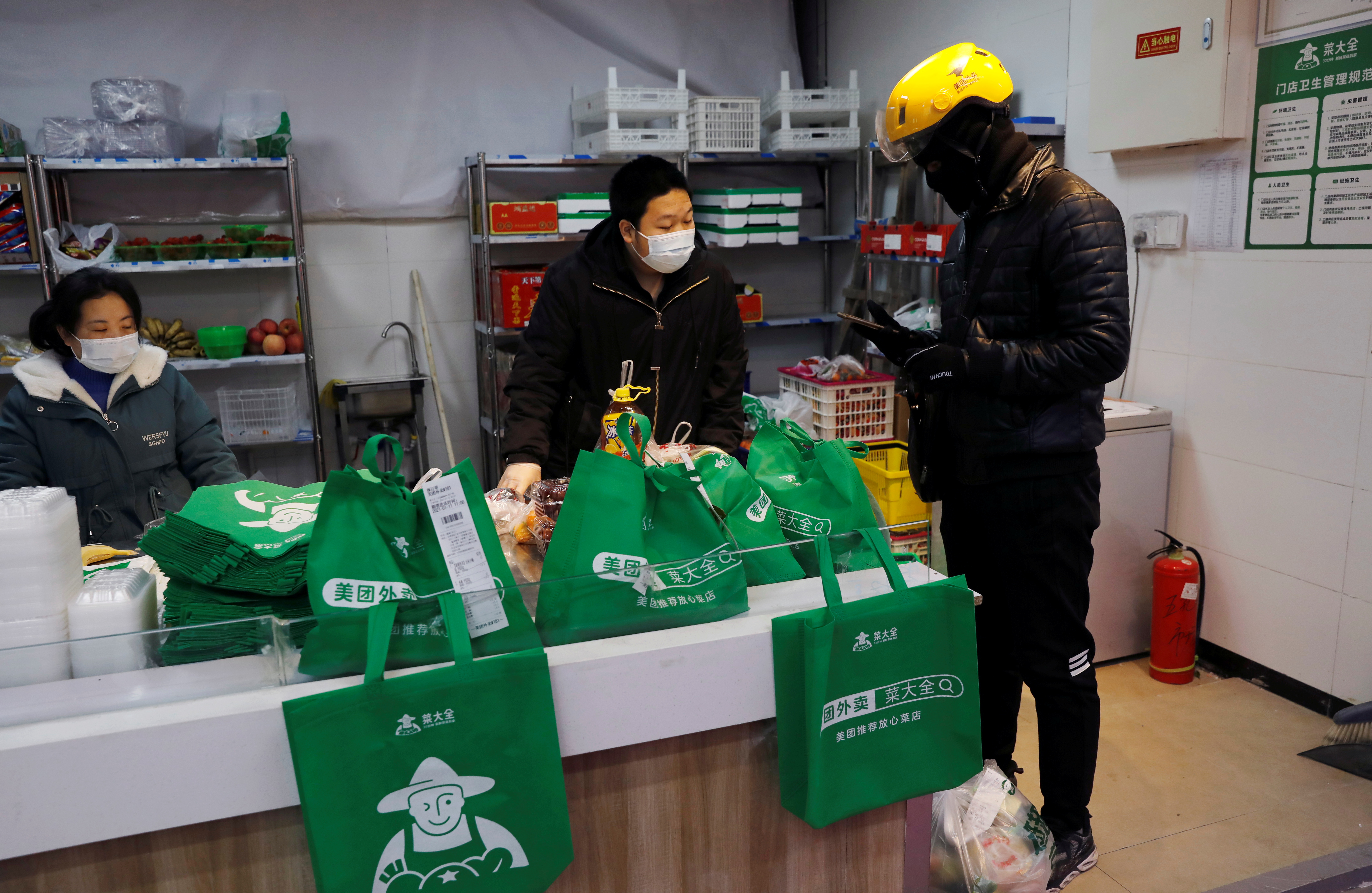 People wearing face masks shop at a market, following new cases of the coronavirus disease (COVID-19) in the country, in Beijing