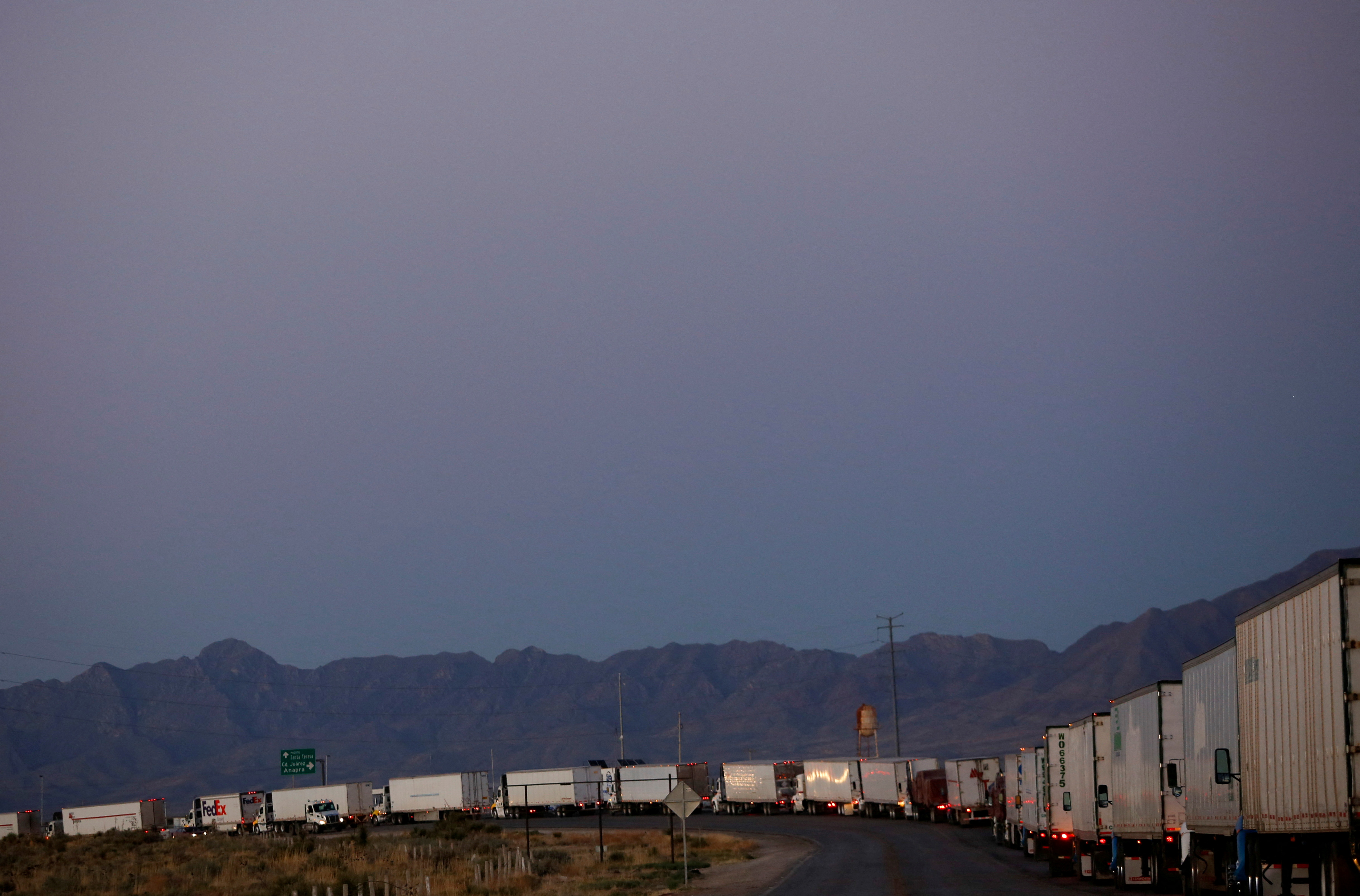 Trucks wait in a queue to cross into the United States