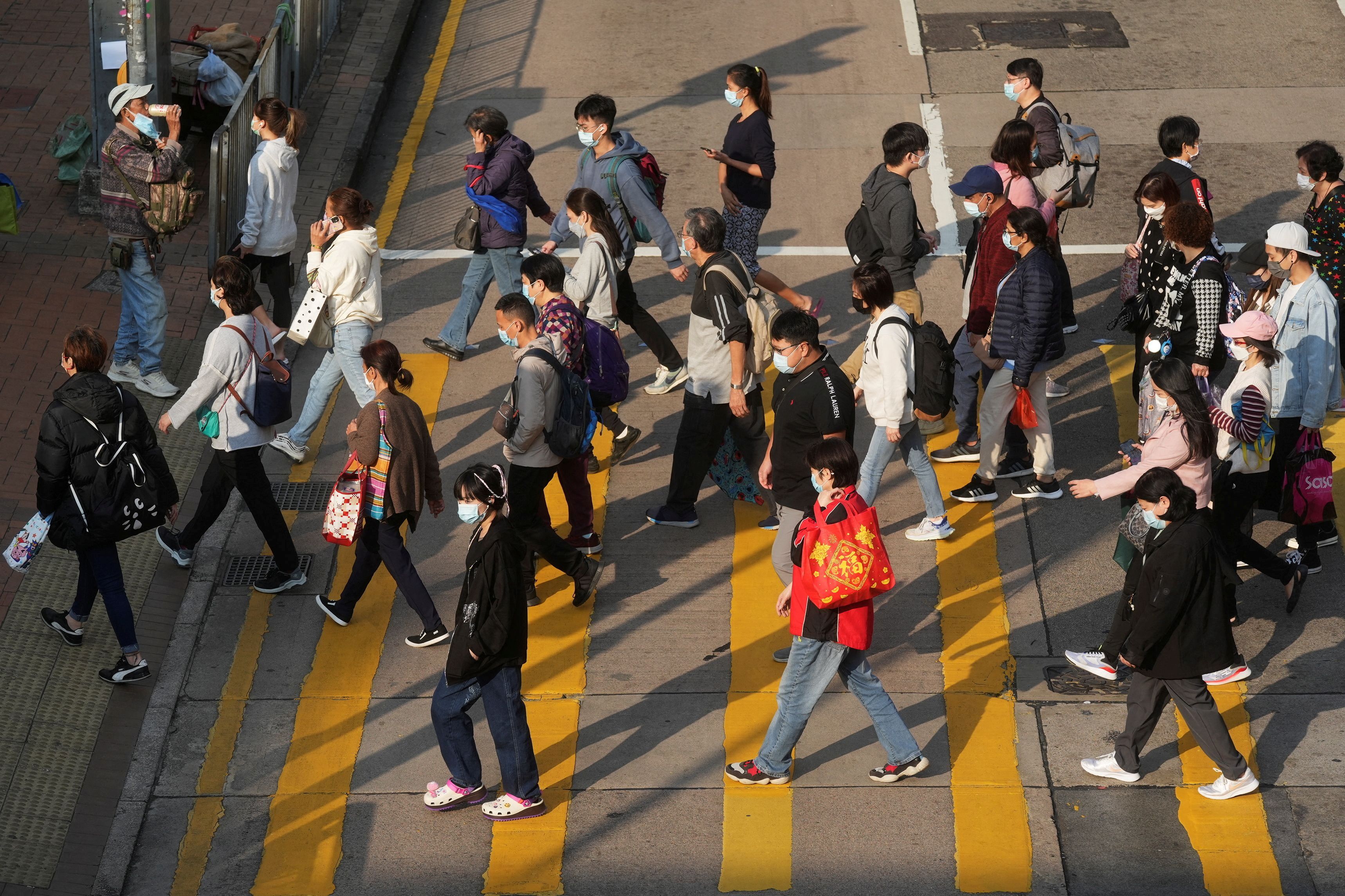 People wearing face masks cross a street following the coronavirus disease (COVID-19) outbreak, in Hong Kong