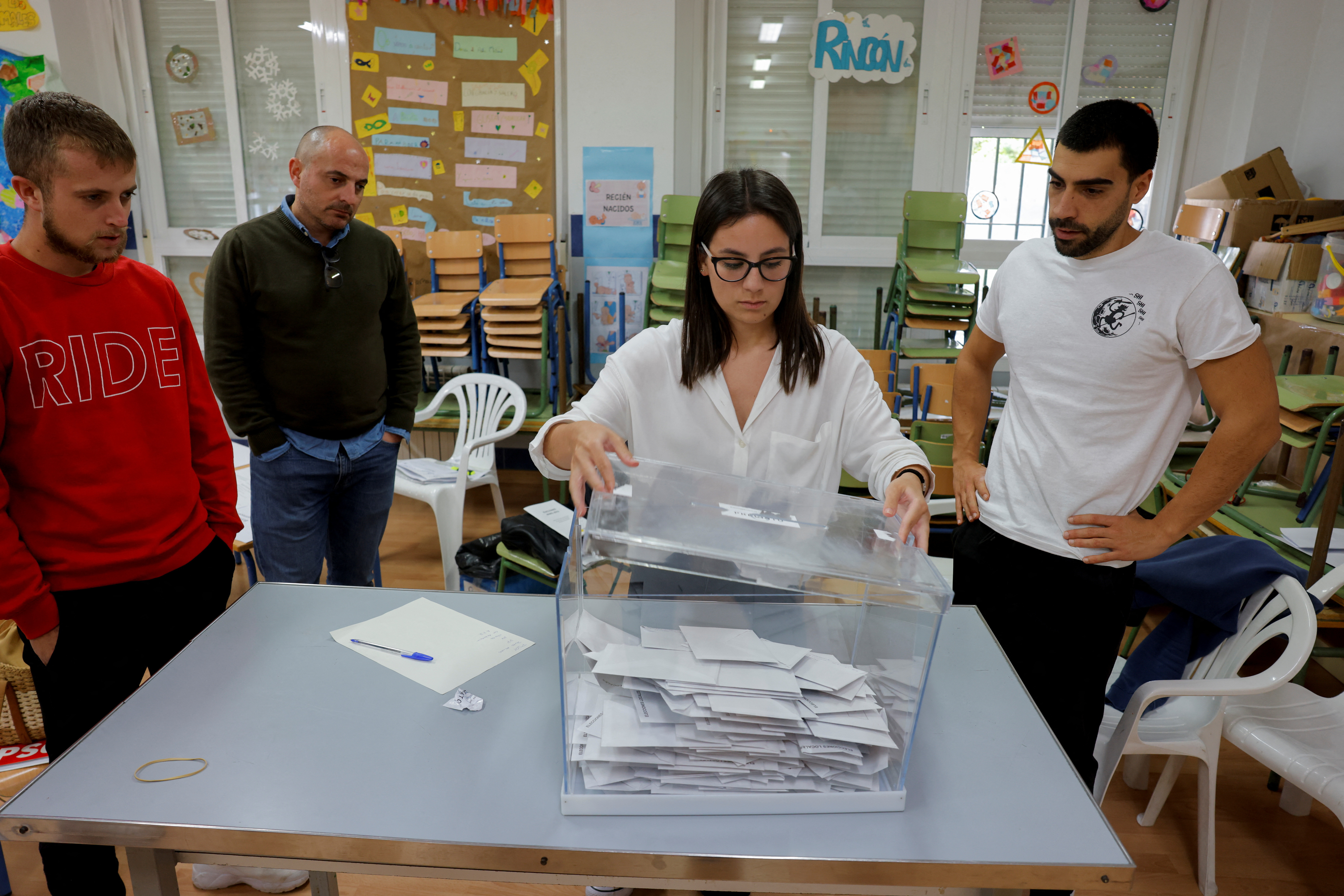 The president of an electoral table opens the ballot box to count the ballots of the local elections, in Ronda