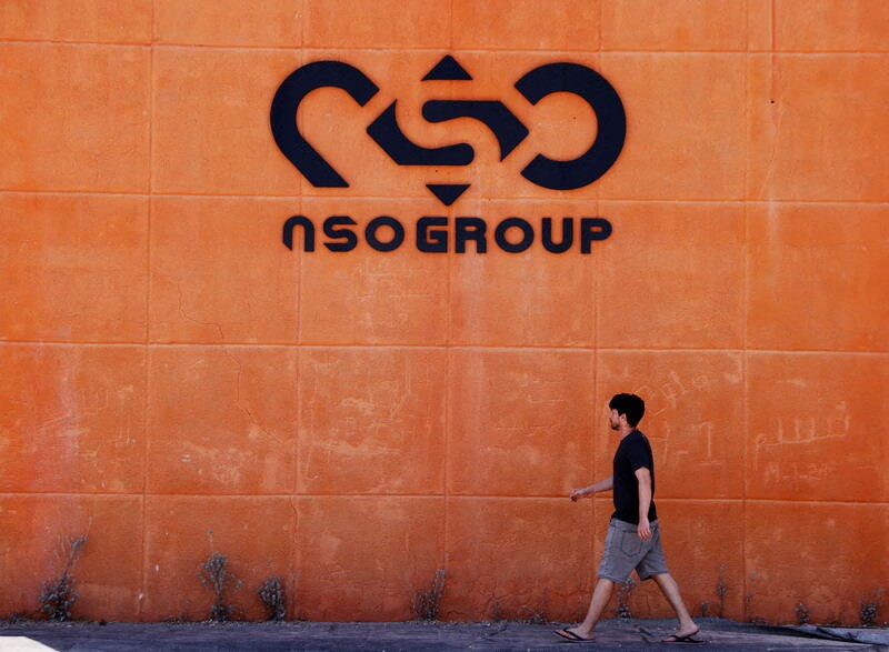 A man walks past the logo of Israeli cyber firm NSO Group at one of its branches in the Arava Desert, southern Israel