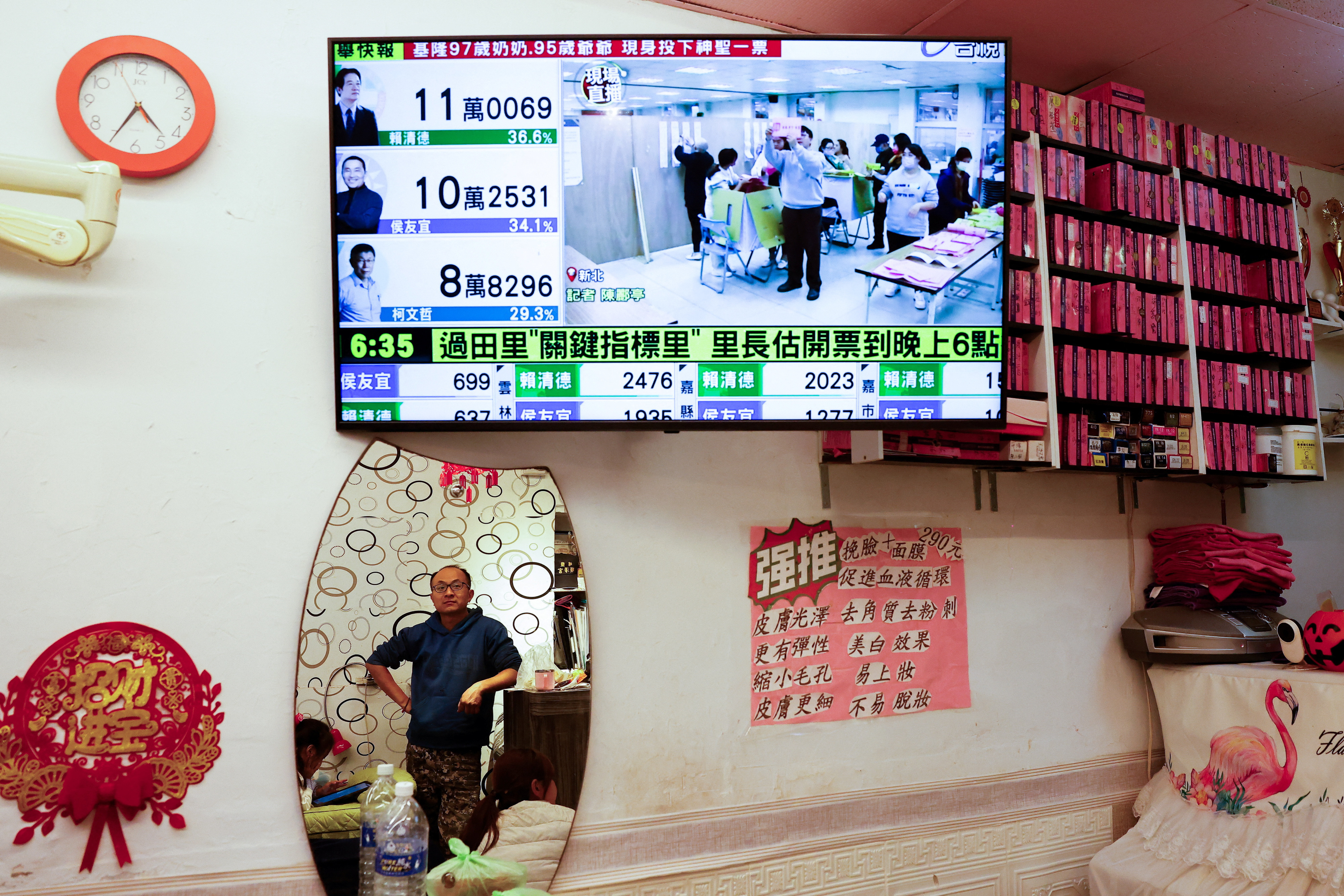 A screen shows a news update on the polling in the presidential and parliamentary elections in Taipei