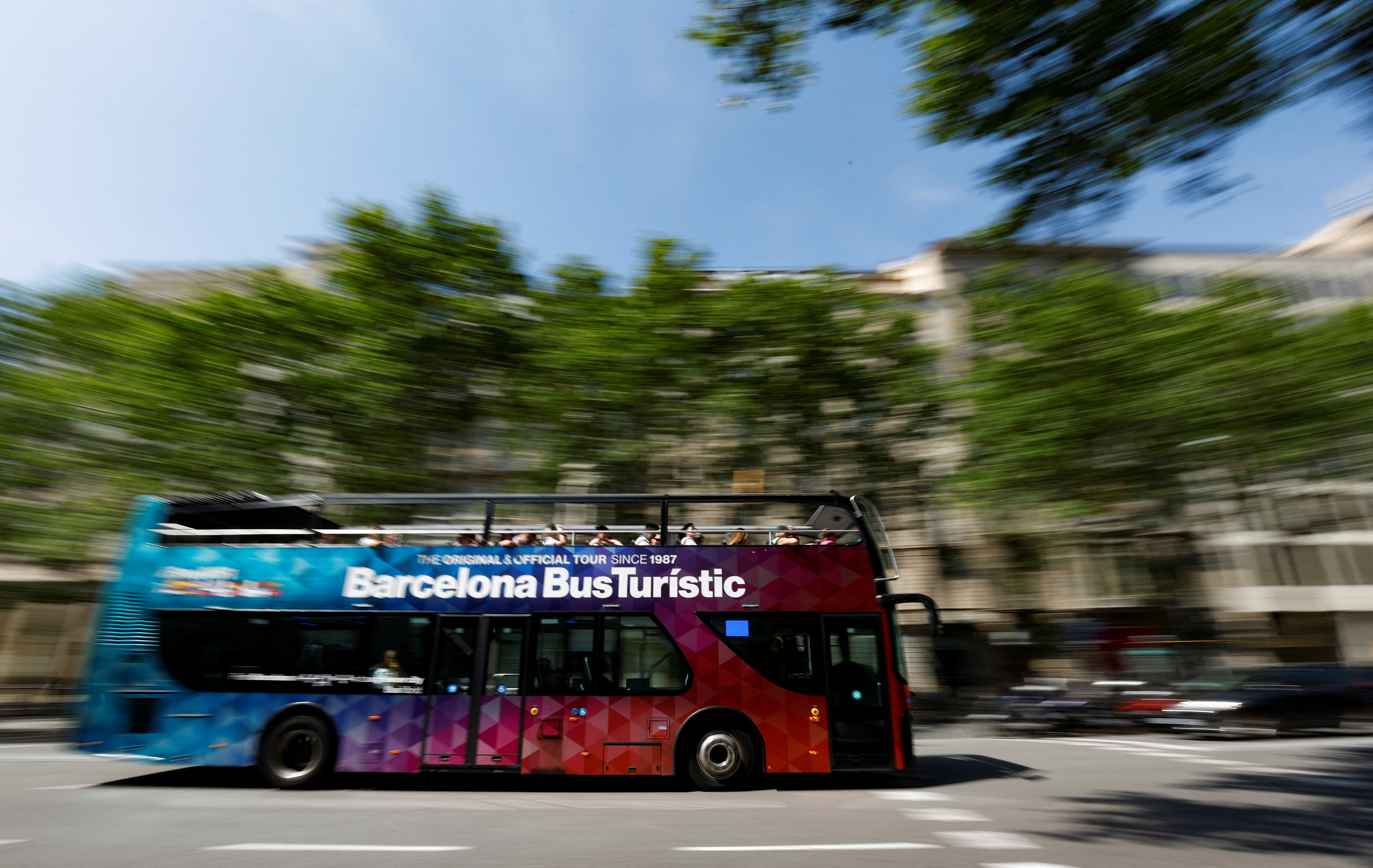 A tourist bus passes by Passeig de Gracia in Barcelona