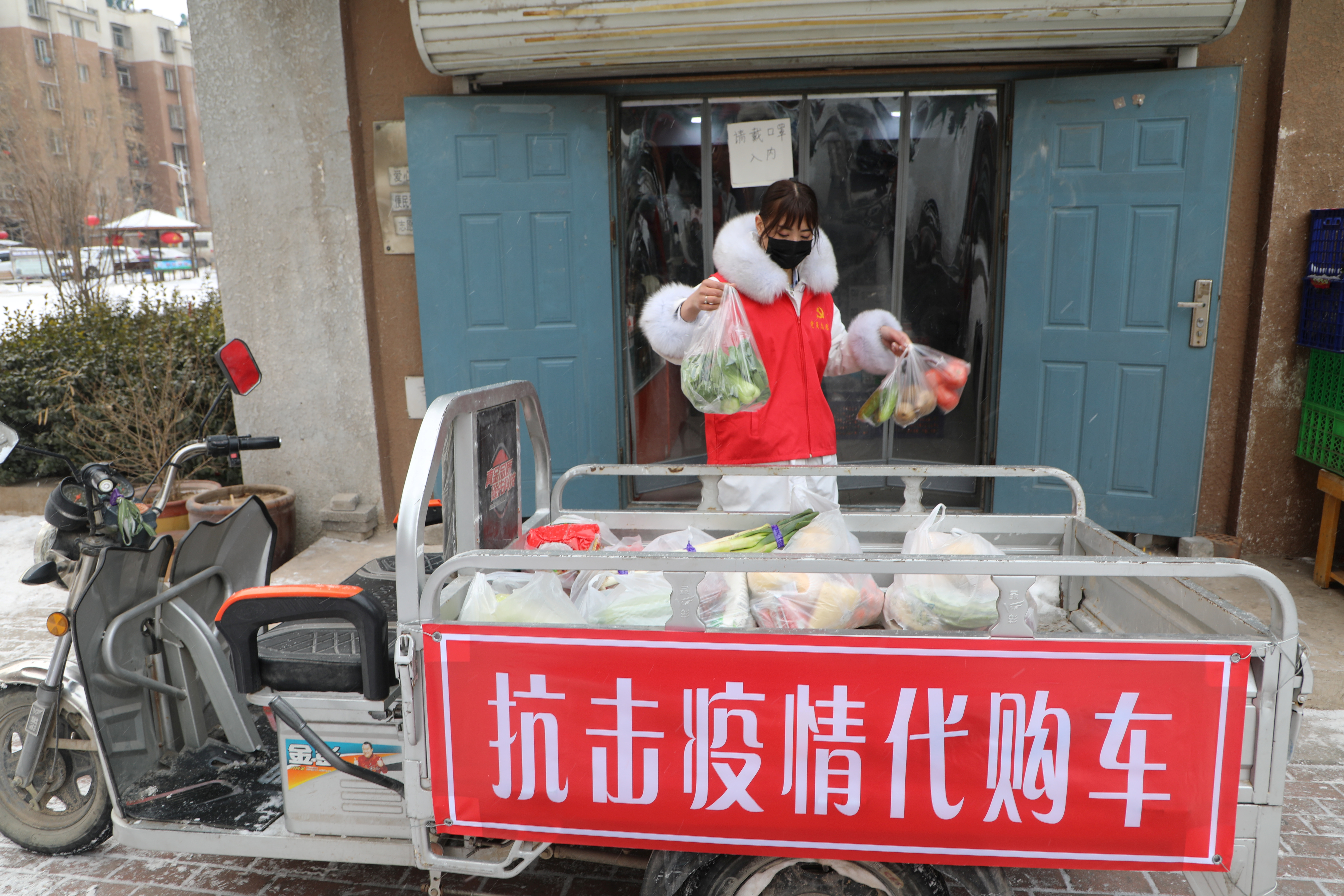 Volunteer helps residents who are affected by the measures to prevent and control the novel coronavirus to purchase daily necessities from a store in Tangshan