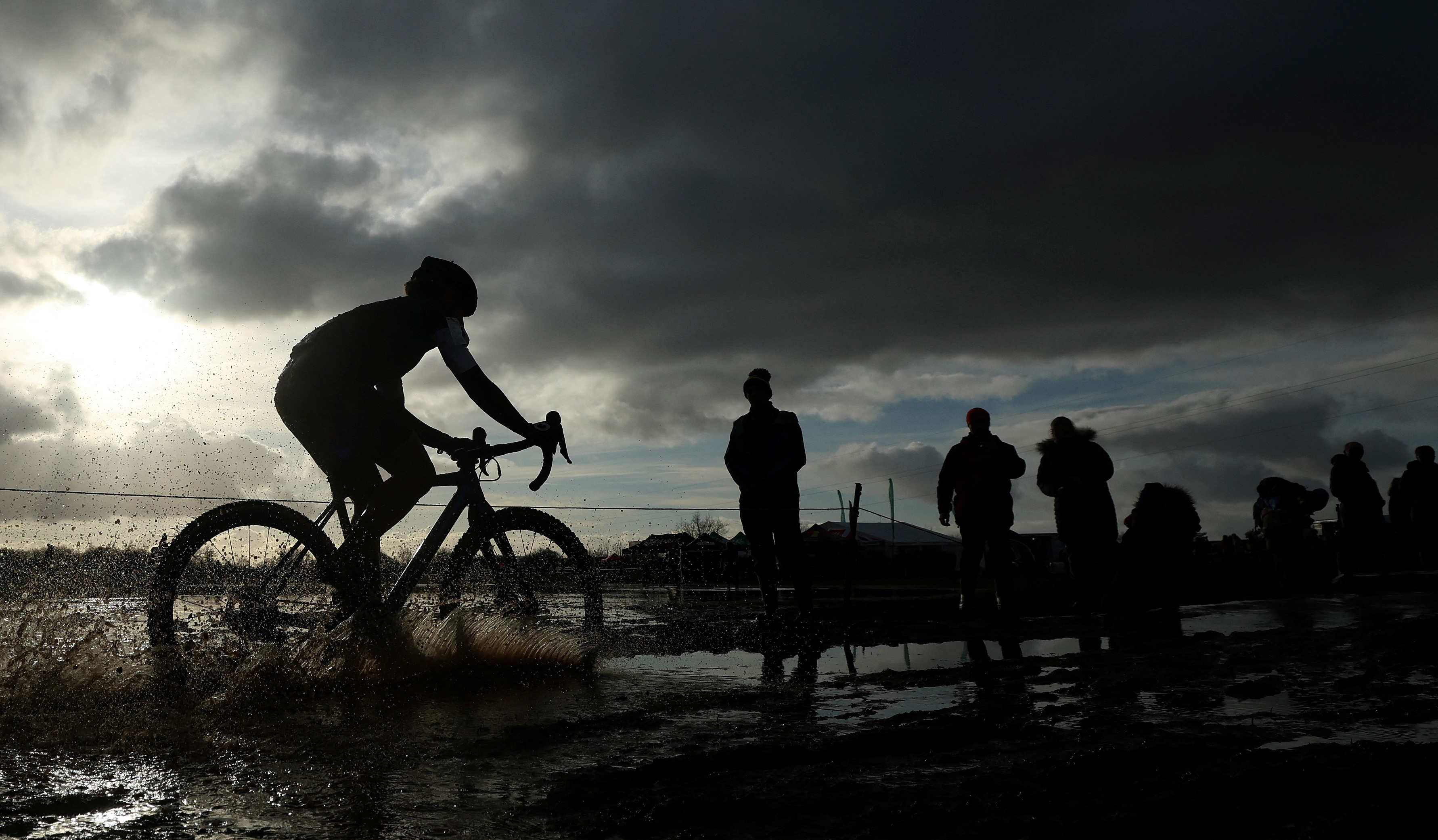 A competitor cycles through a puddle during the Senior Women's race at the British Cyclocross championships near Milnthorpe