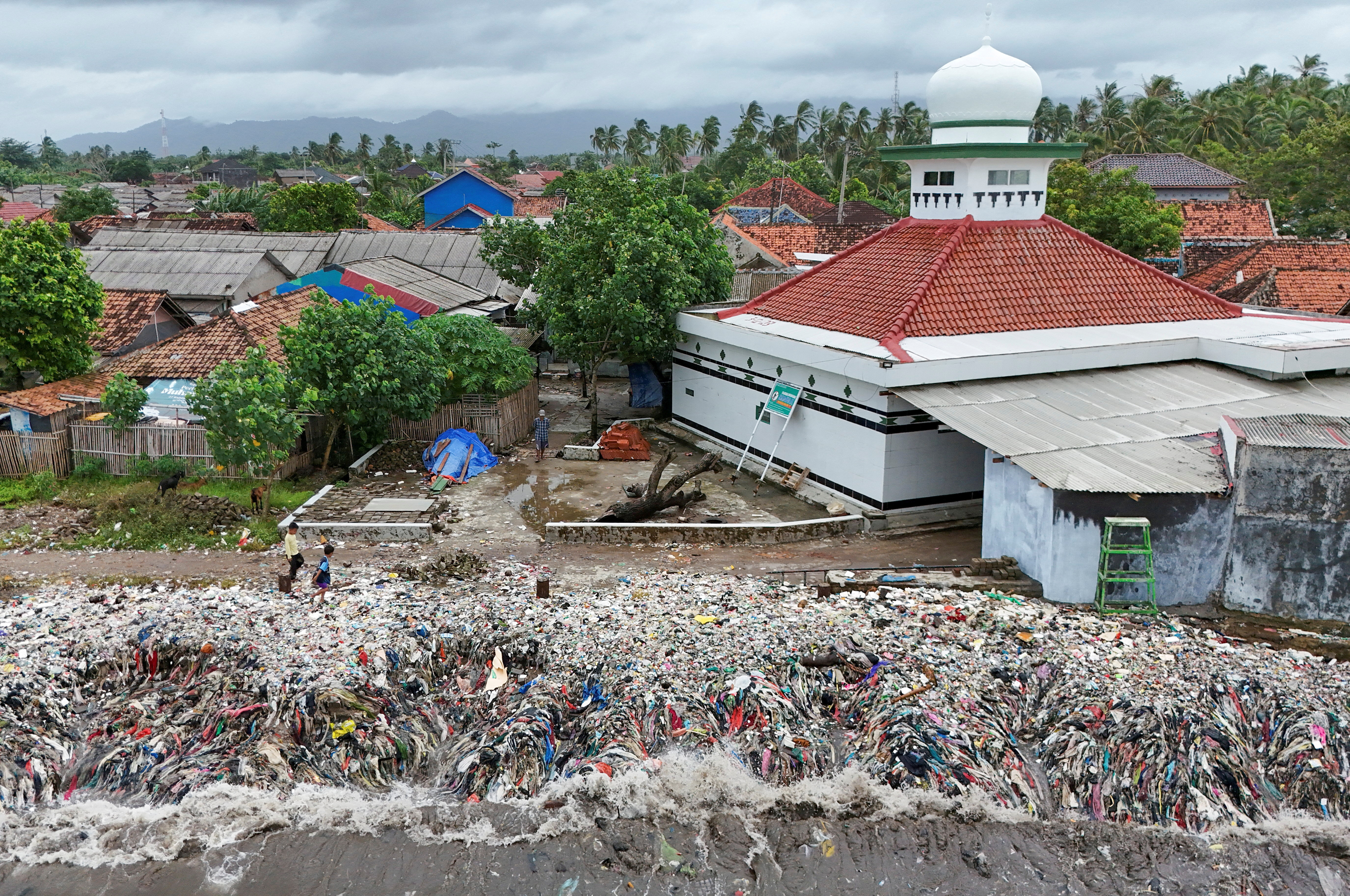 Indonesian fishing village grapples with piles of trash amid erratic high tides