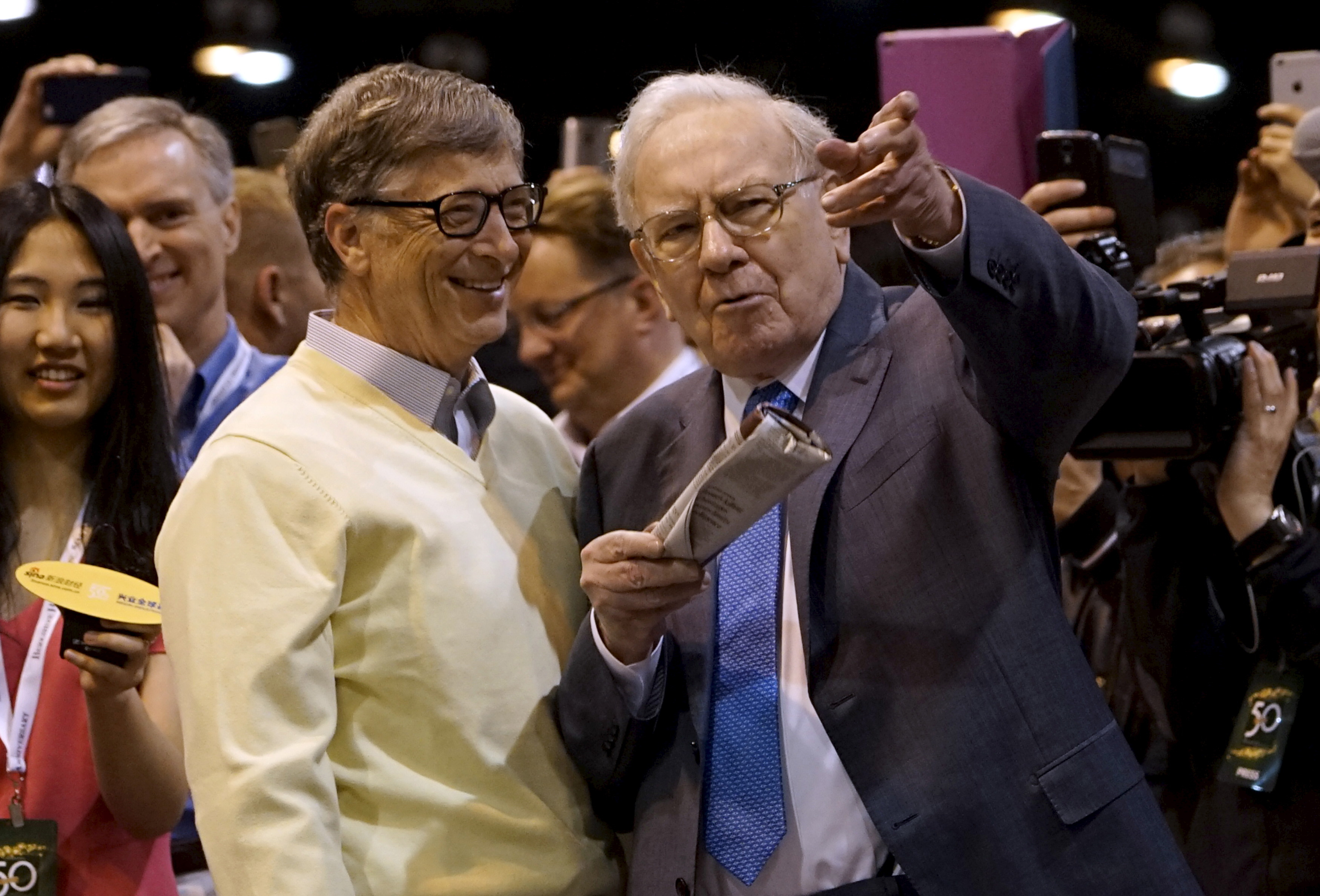 Berkshire Hathaway CEO Warren Buffett shows his friend Microsoft co-founder Bill Gates the finer points of newspaper tossing, prior to the Berkshire annual meeting in Omaha