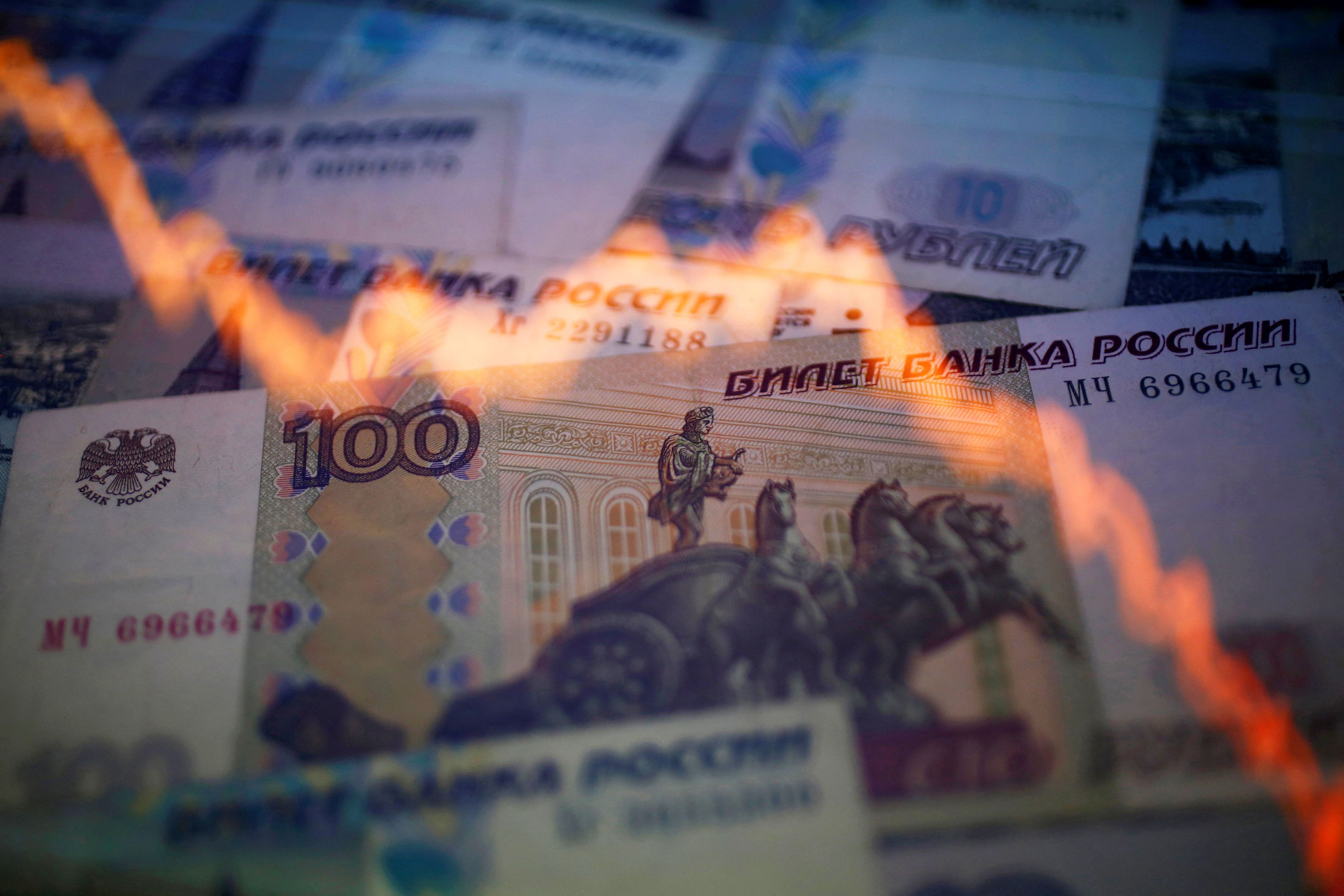 A reflection of a yearly chart of U.S. dollars and Russian roubles are seen on rouble notes in this photo illustration taken in Warsaw