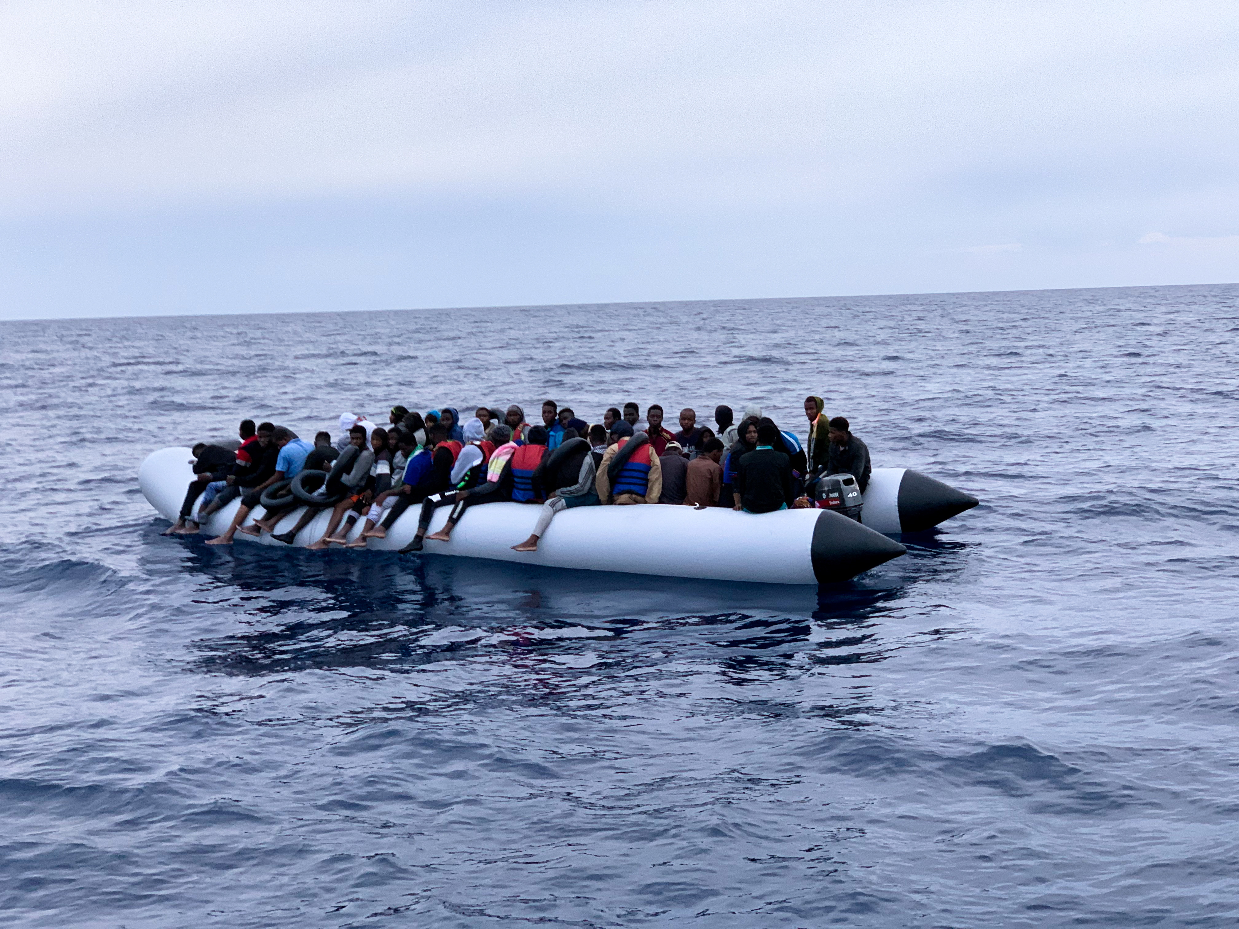 Migrants are seen on a rubber dinghy as Libyan Coast Guards arrive to rescue them in the Mediterranean Sea, off the coast of Libya
