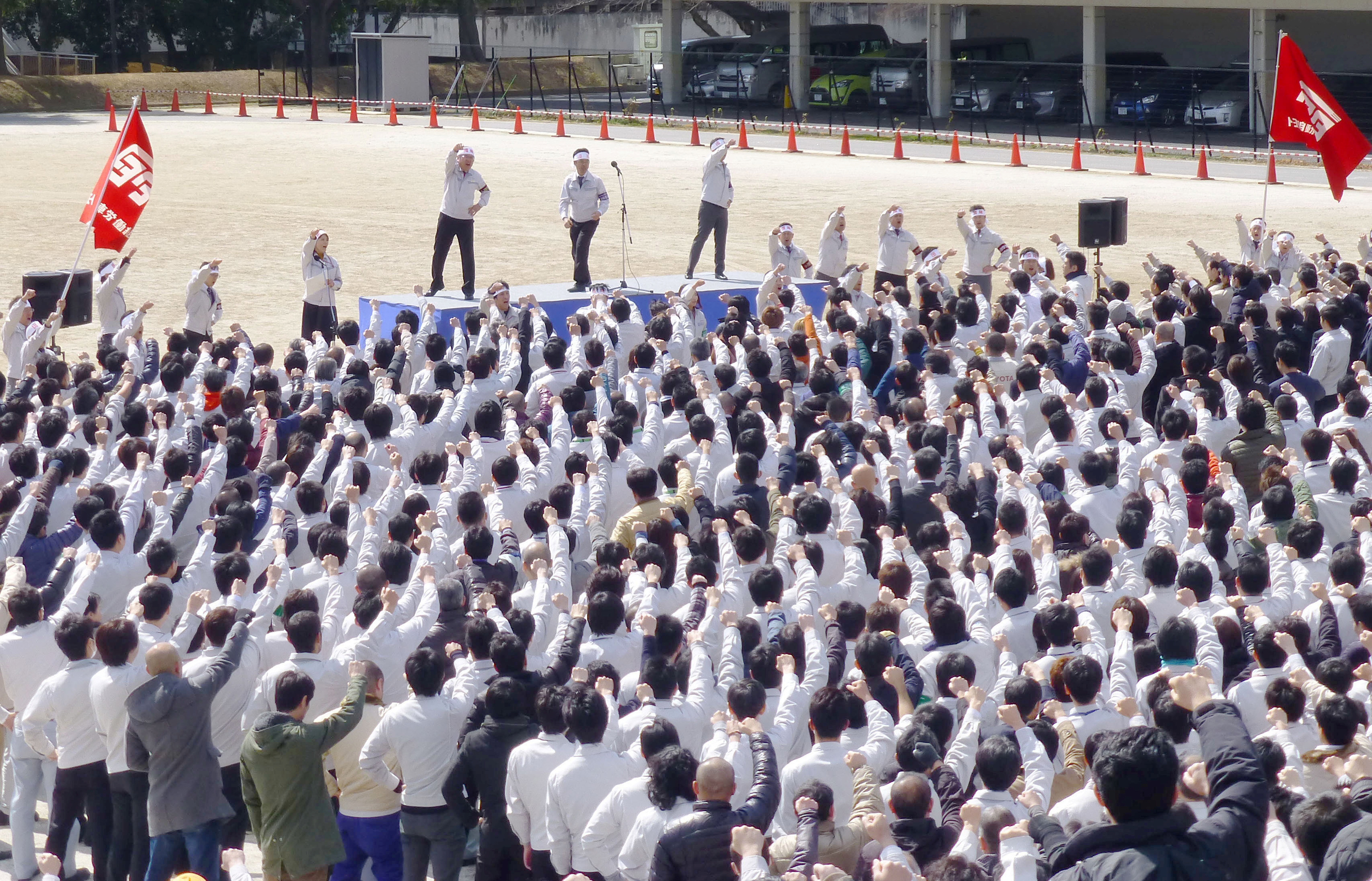 Members of the workers' union of Toyota Motor Corp. raise their fists as they shout slogans during a rally for the annual "shunto" wage negotiations at the company headquarters in Toyota