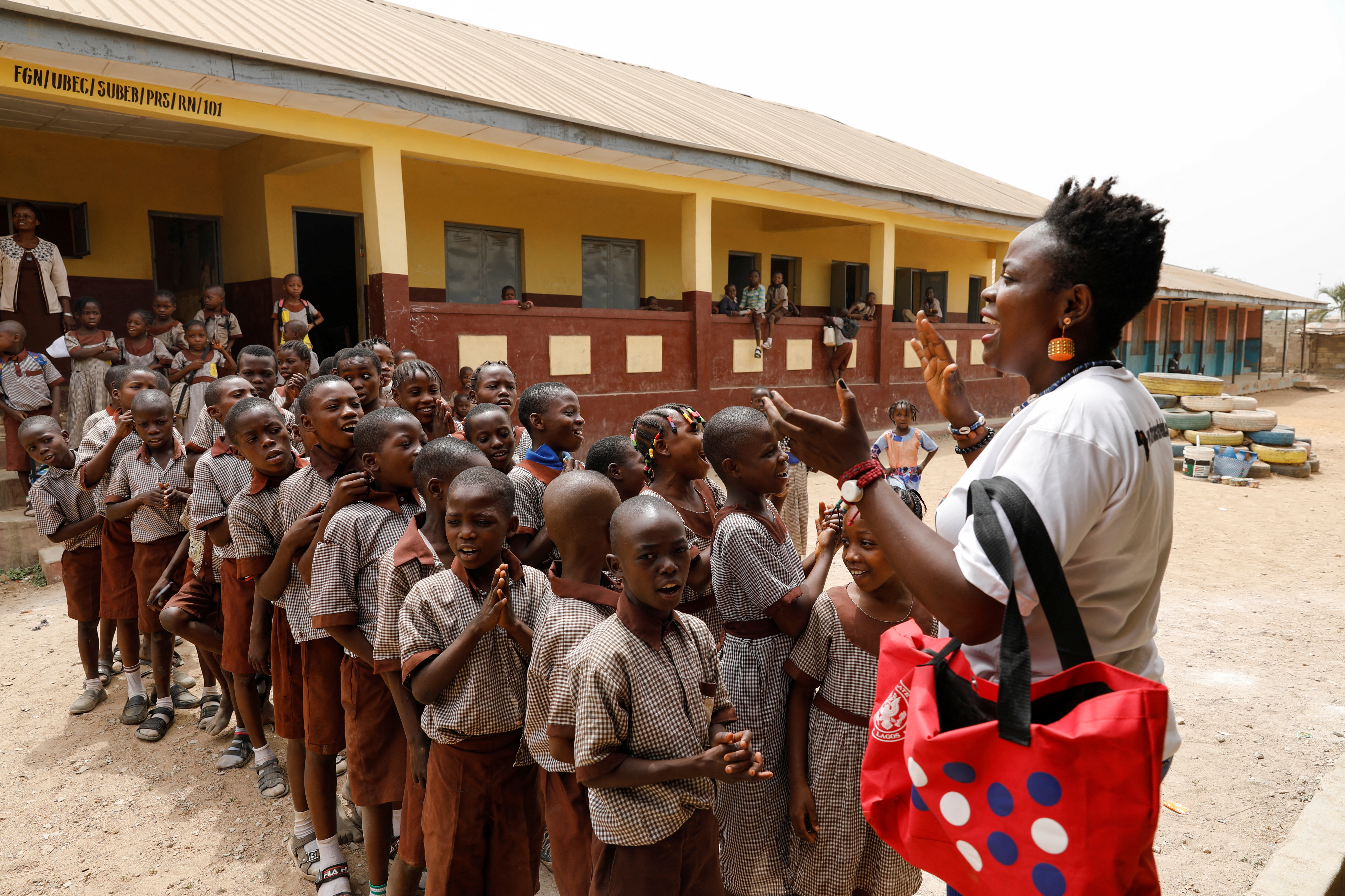 Waste Museum founder Olowookere speaks to children at a school, in Ibadan
