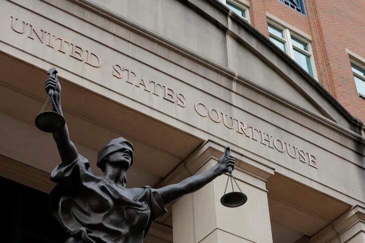 A bronze statue titled "Justice Delayed, Justice Denied" depicting a figure of Justice is seen on the Albert V. Bryan United States Courthouse in Alexandria, Virginia