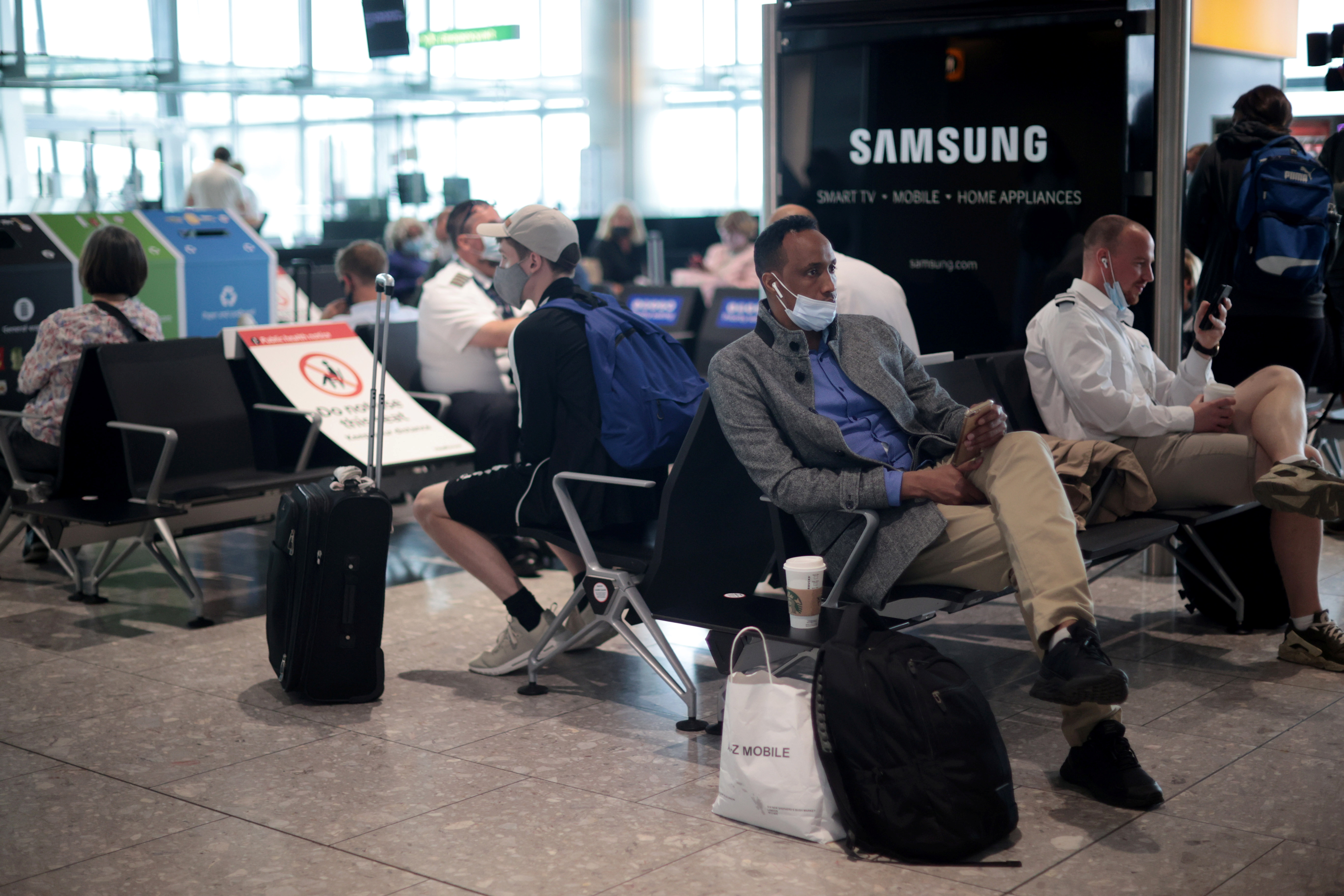 Passengers wait at the Terminal 5 departures area at Heathrow Airport in London