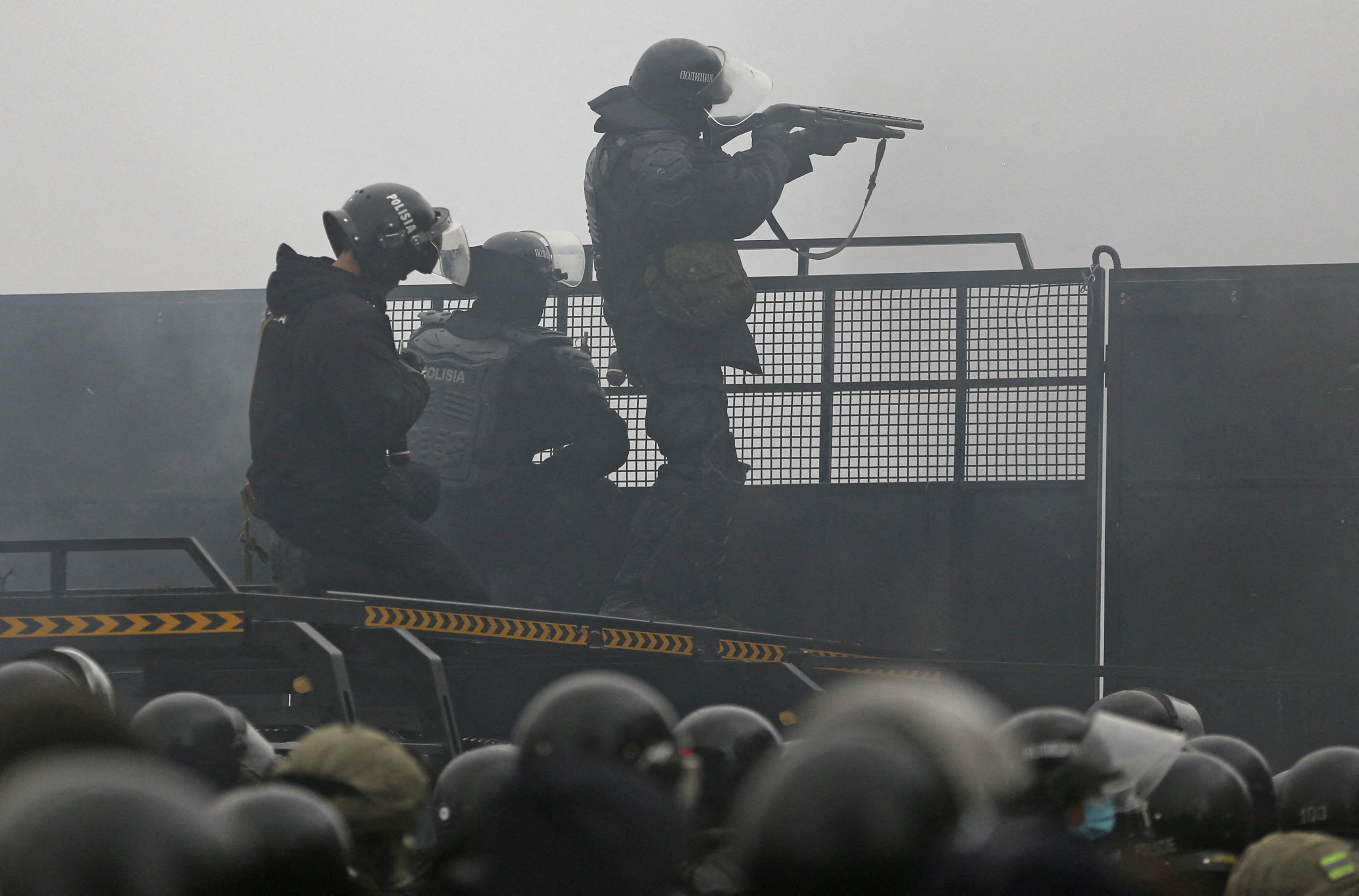 Kazakh law enforcement officers are seen on a barricade during a protest triggered by fuel price increase in Almaty, Kazakhstan January 5, 2022. REUTERS/Pavel Mikheyev