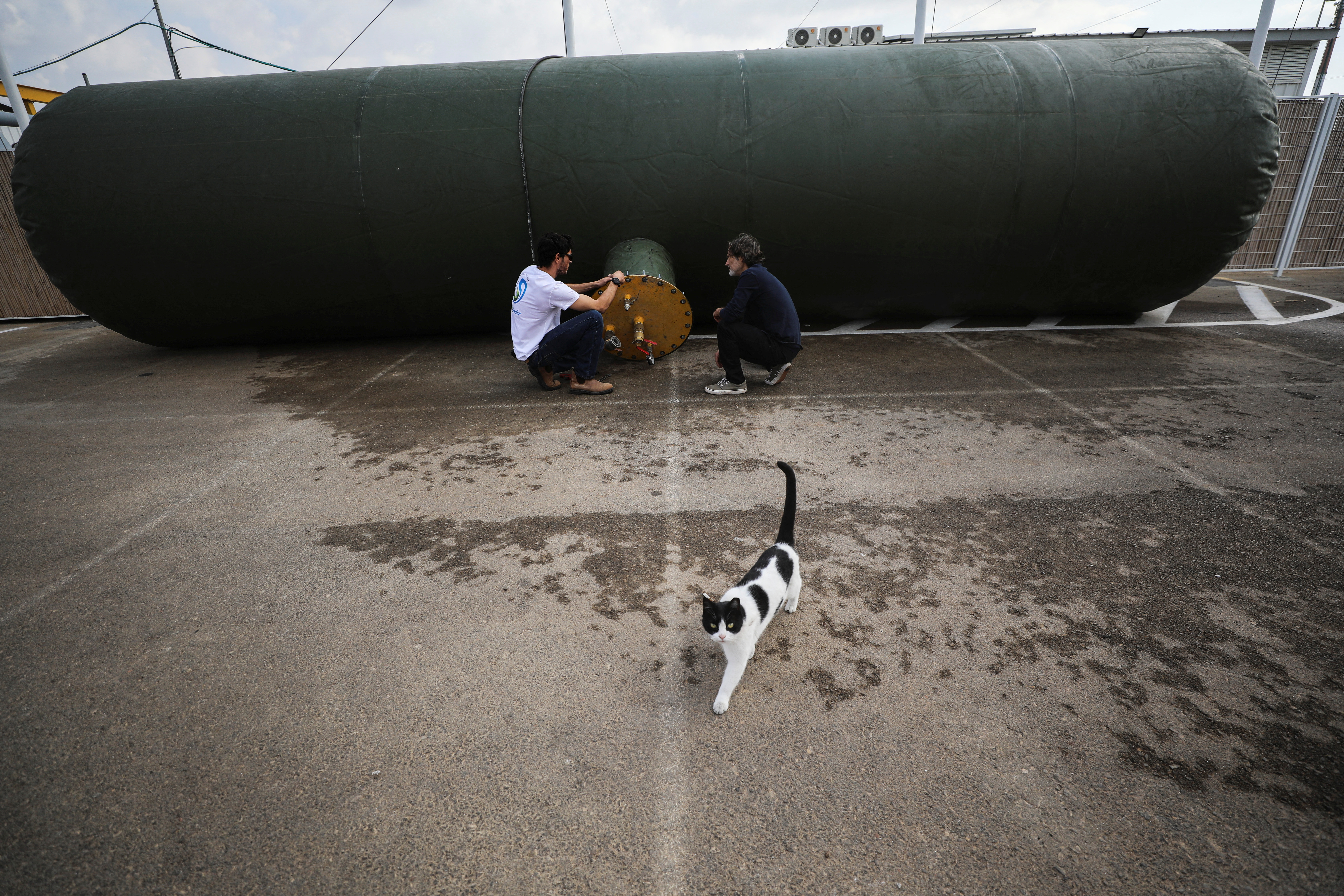 Employees kneel by the lining of an air storage tank at Augwind's headquarters in Kibbutz Yakum, Israel