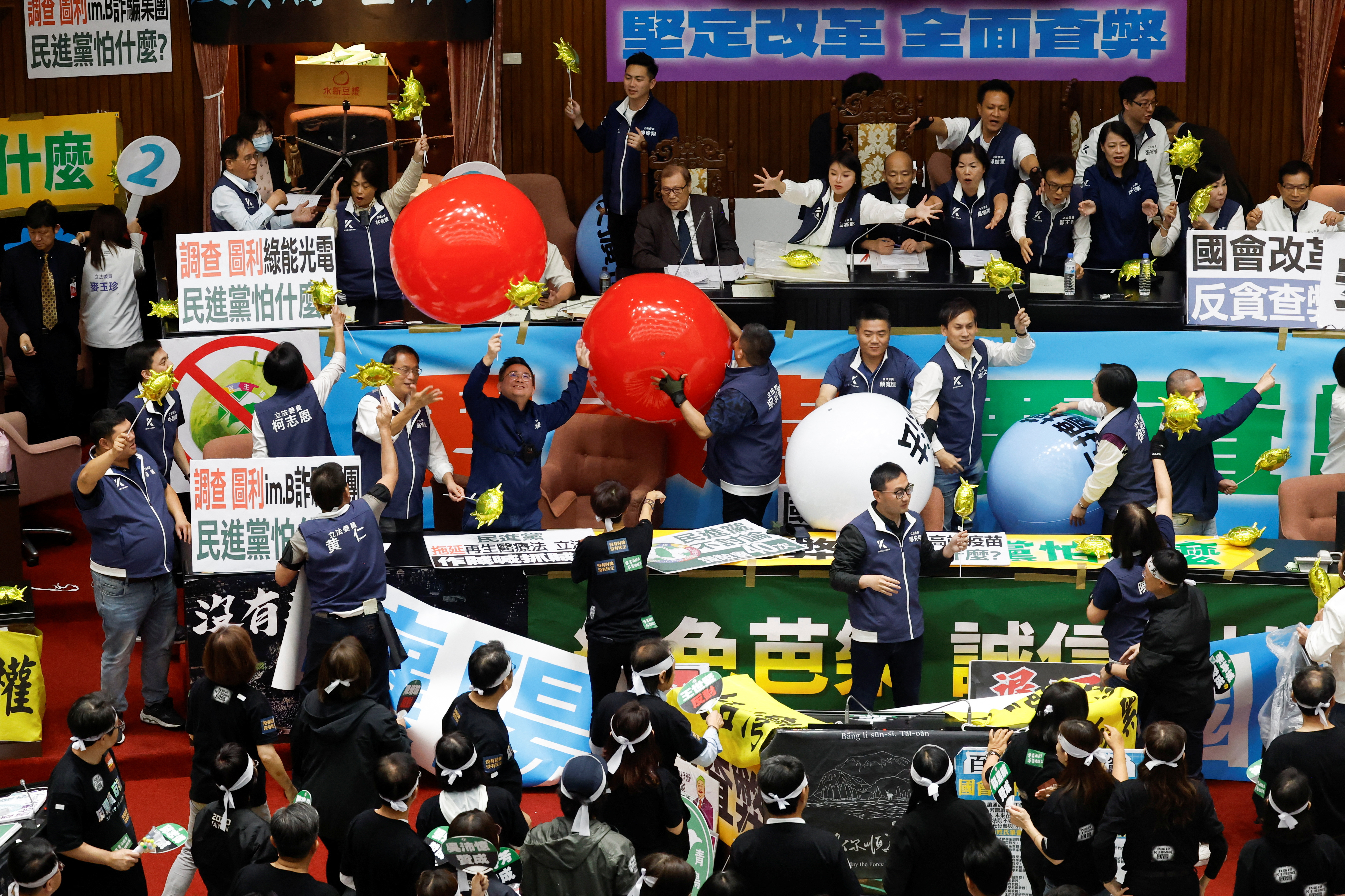 Lawmakers take part in a session as some hold inflatable balloons, at the Parliament in Taipei