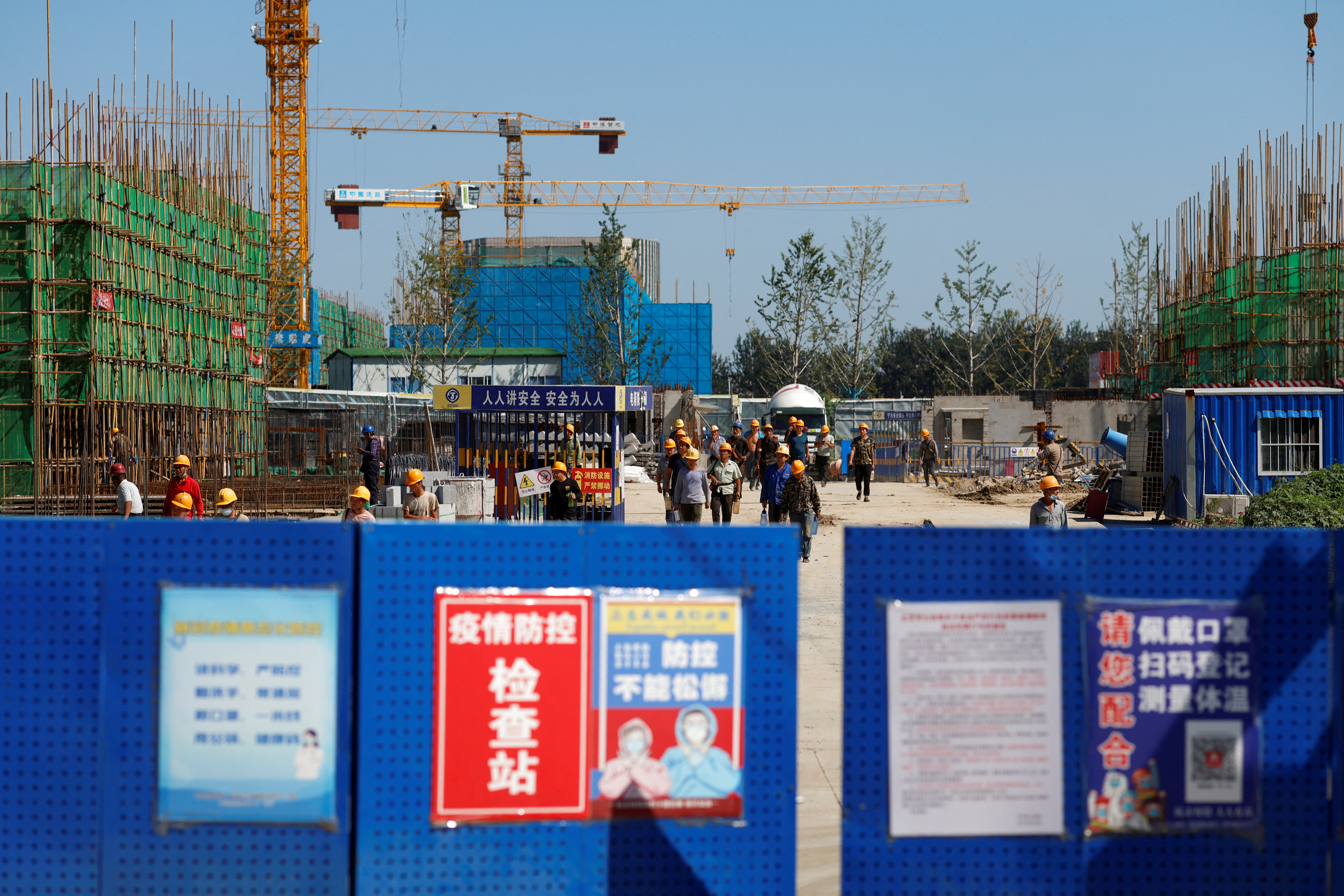 Workers walk inside the construction site of a project developed by China Evergrande Group in Beijing