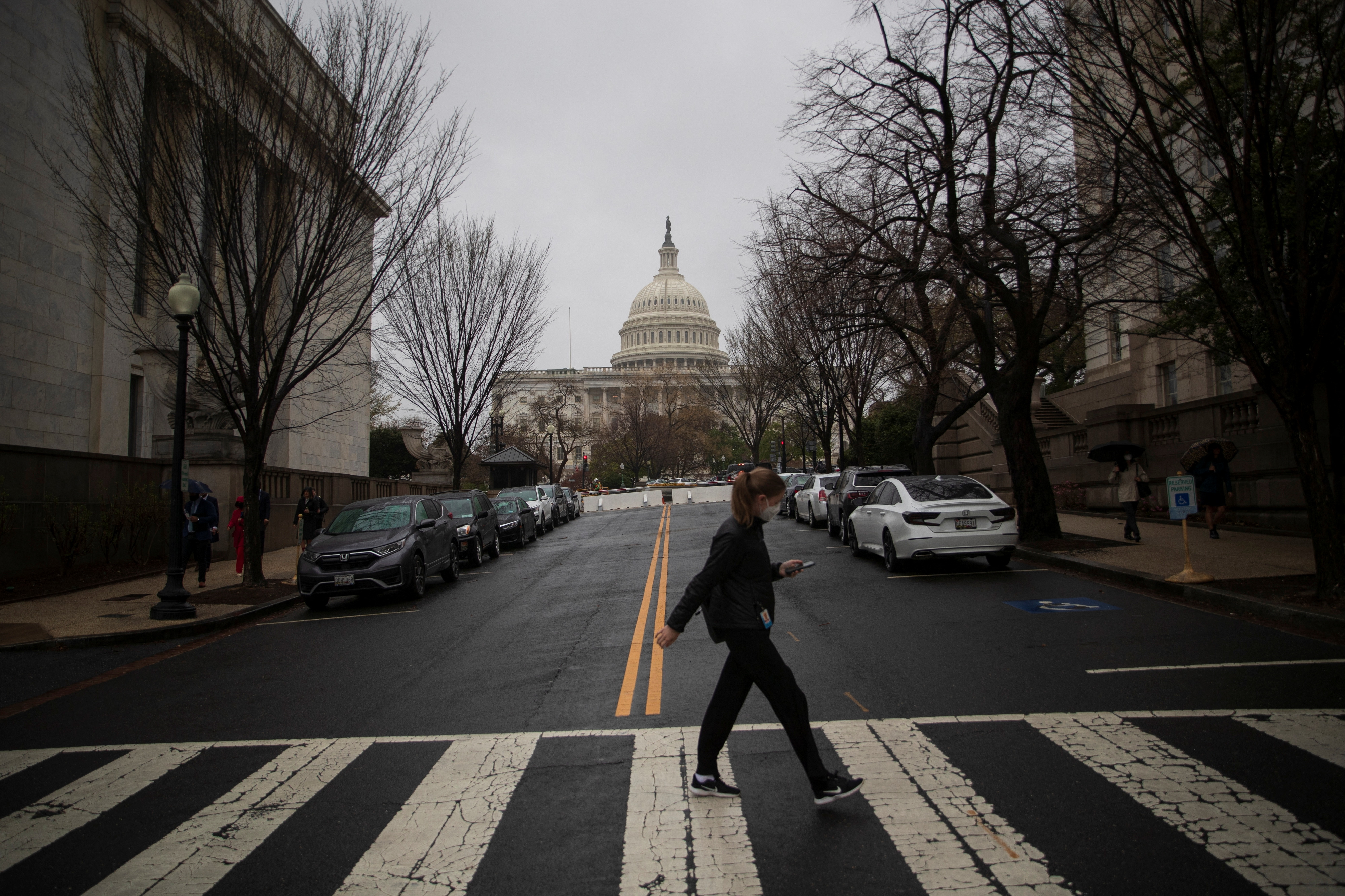 A visitor uses a crosswalk near the Longworth House Office Building on Capitol Hill in Washington