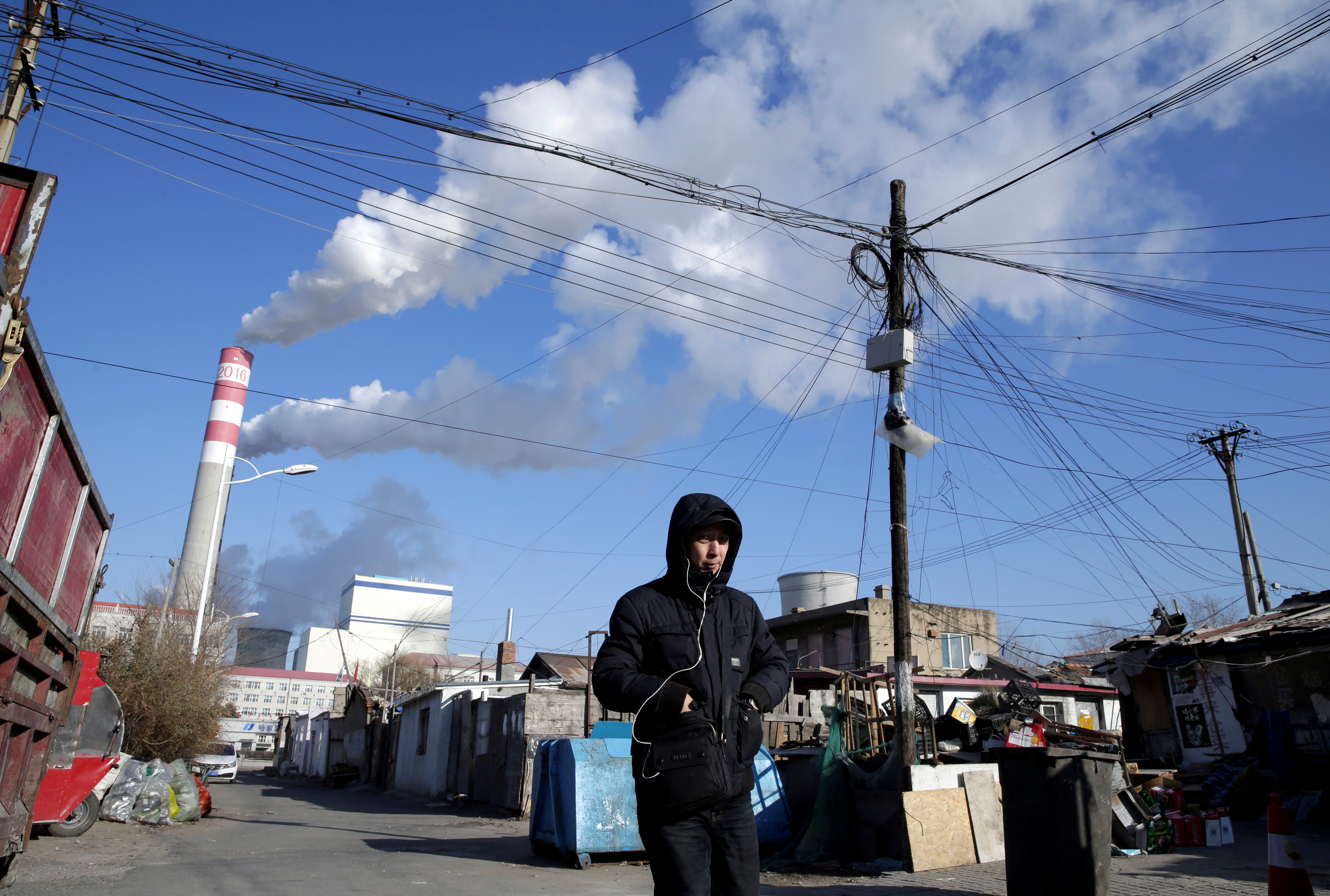 A man walks near a coal-fired power plant in Harbin
