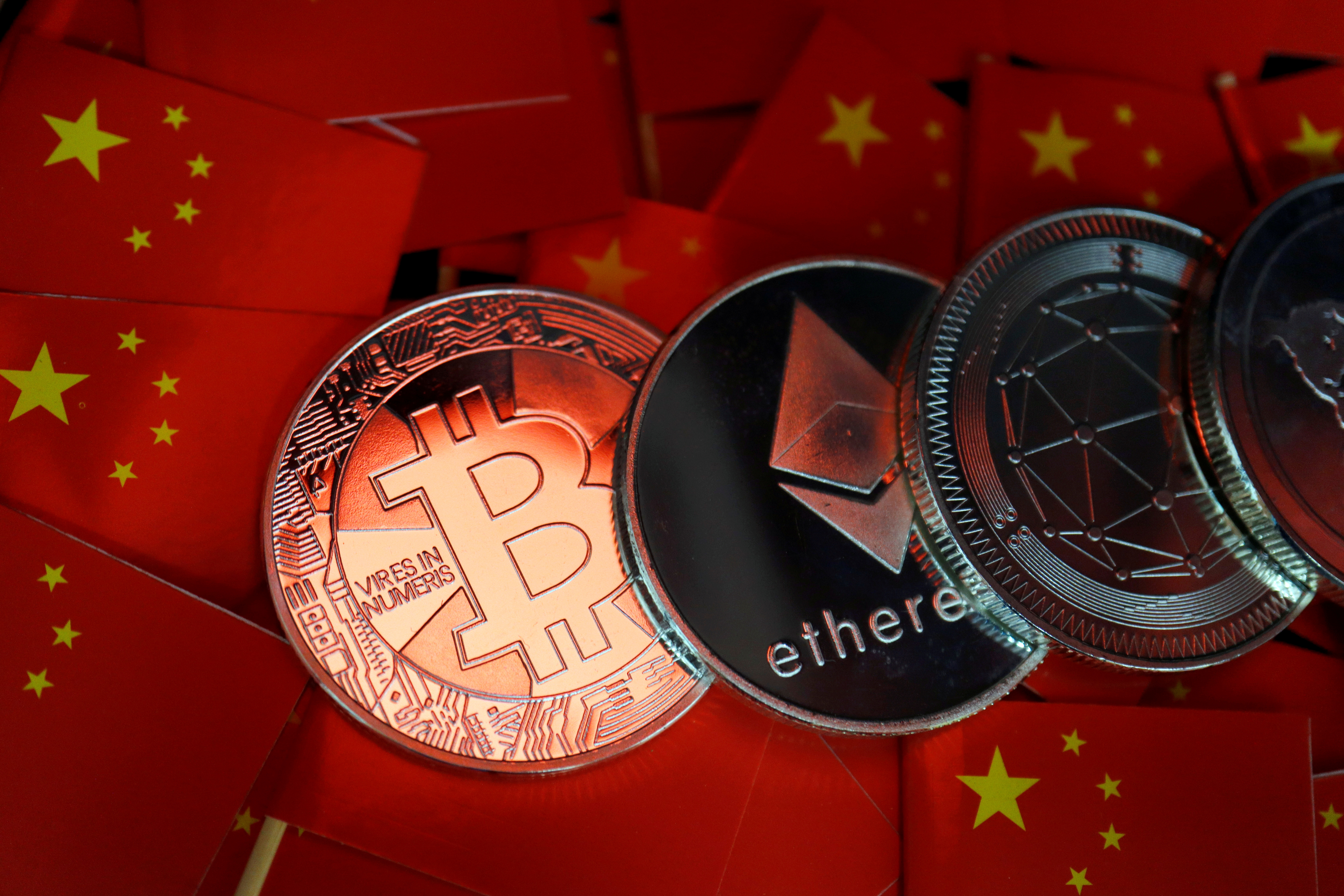 Representations of Bitcoin and other cryptocurrencies are seen amid China's flags in this illustration picture taken September 27, 2021. REUTERS/Florence Lo/Illustration