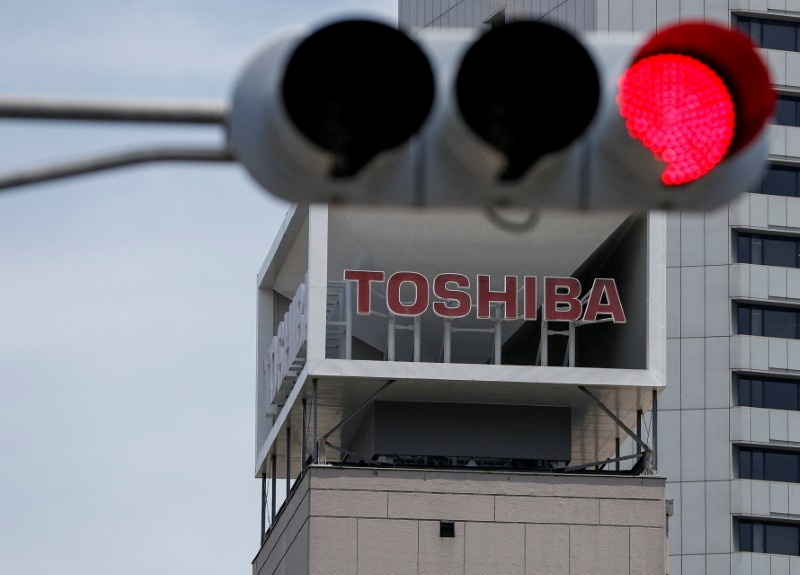 FILE PHOTO: The logo of Toshiba Corp. is seen next to a traffic signal atop of a building in Tokyo, Japan June 11, 2021.  REUTERS/Issei Kato/File Photo/File Photo