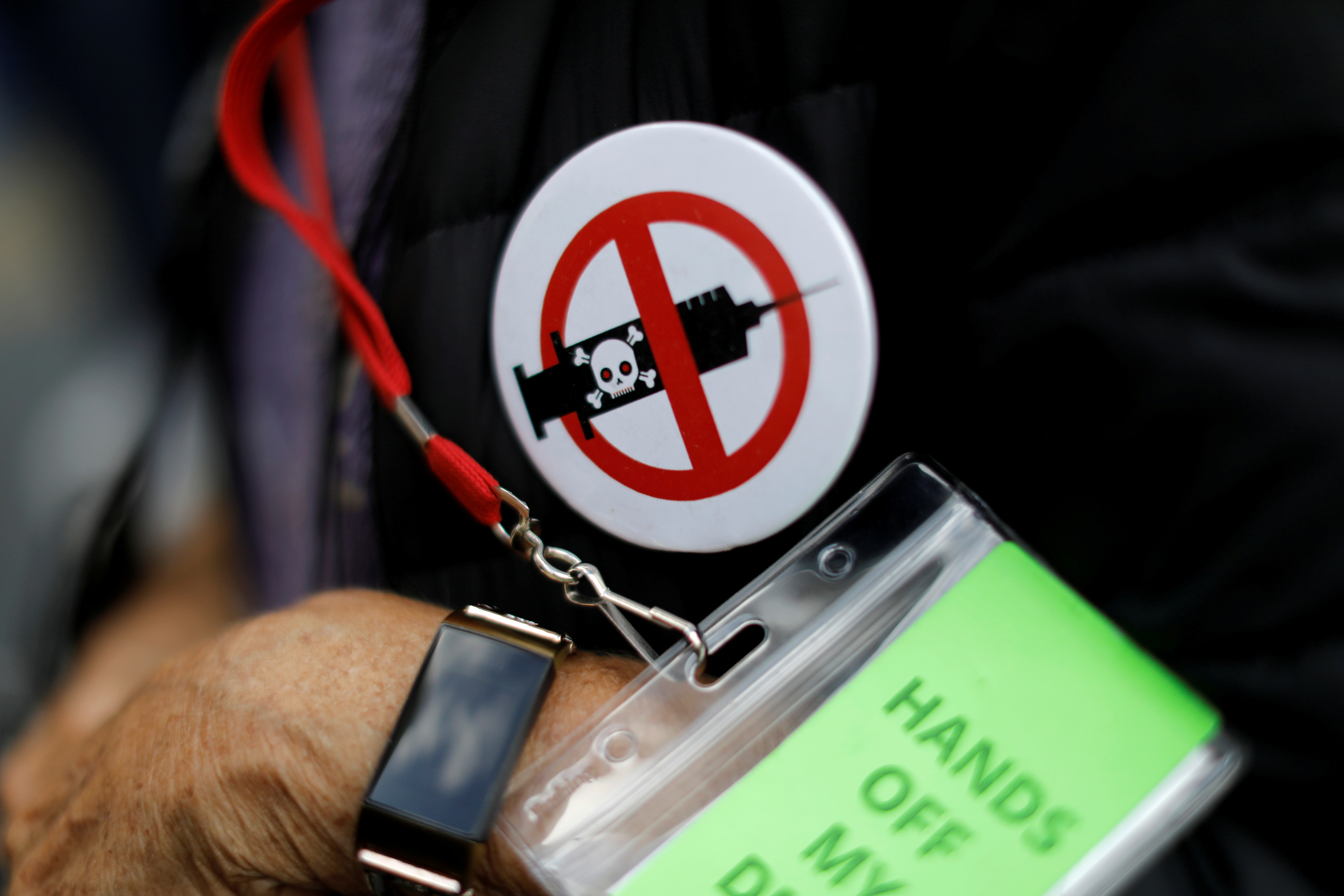 A man wears an anti-vaccine button as people and teachers protest against New York City mandated vaccines against the coronavirus disease (COVID-19) in front of the United States Court in Manhattan in New York City, New York, U.S., October 12, 2021. REUTERS/Mike Segar