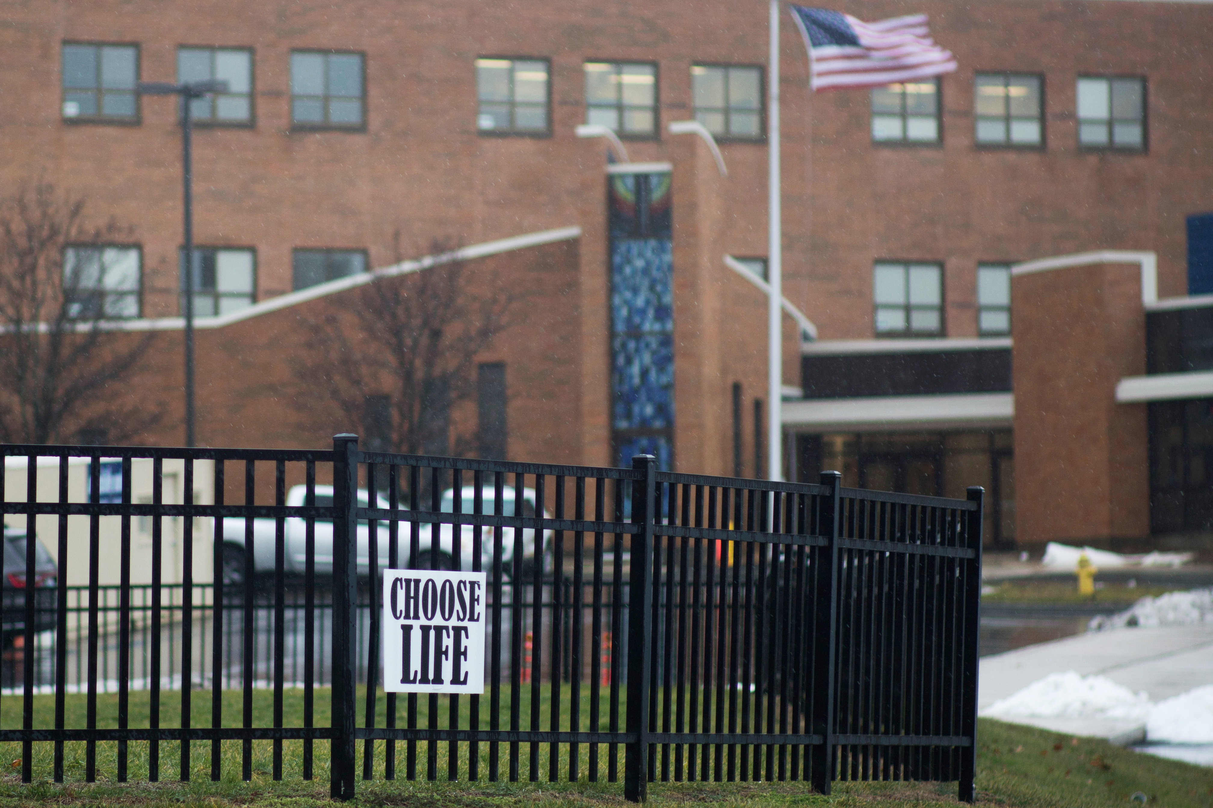 An anti-abortion sign hangs on a fence in front of Covington Catholic High School in Park Hills