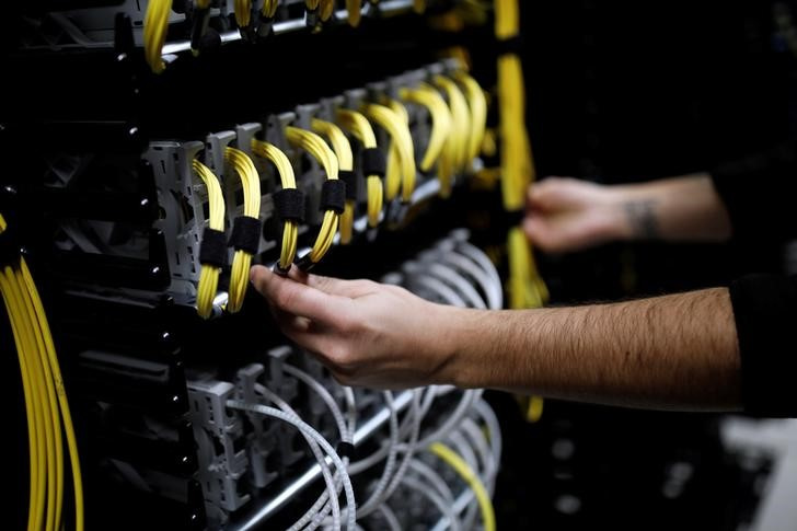 Cables run into the back of a server unit inside the data center of Equinix in Pantin, near Paris