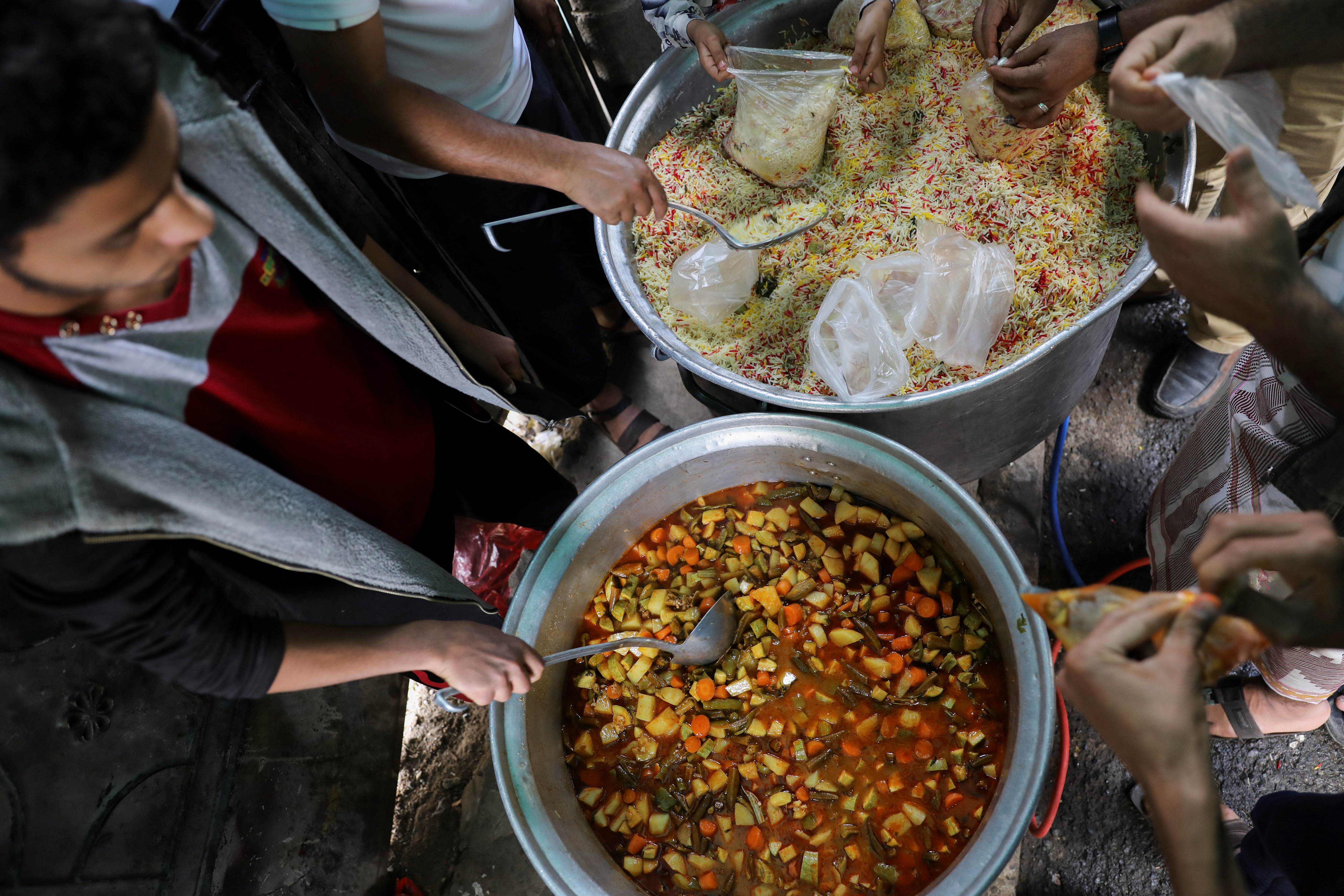 Volunteers prepare meals to be distributed at a charity kitchen during the holy month of Ramadan in Sanaa