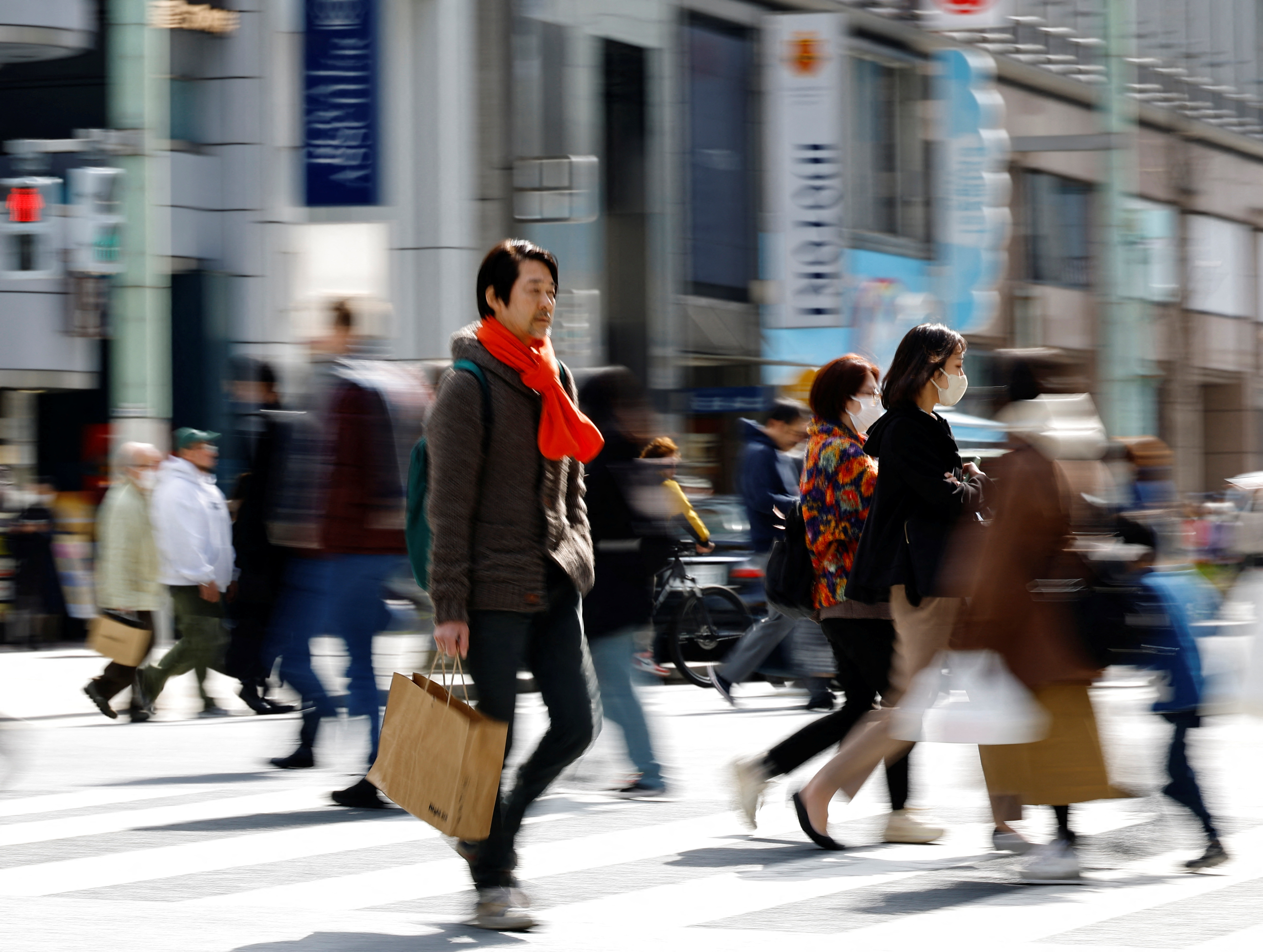 Shoppers make their way at a shopping district in Tokyo