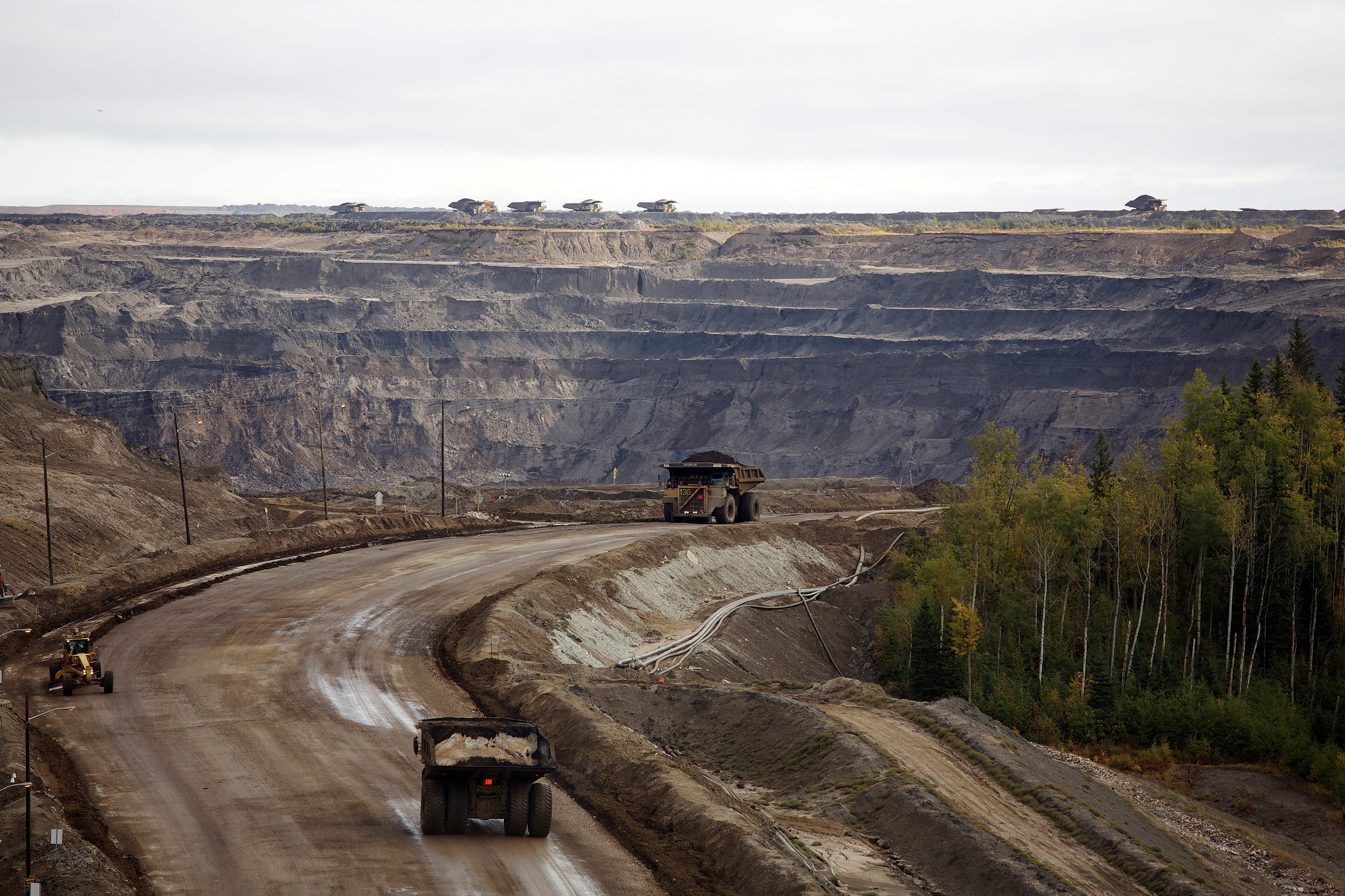 Giant dump trucks haul raw tar sands at the Suncor tar sands mining operations near Fort McMurray.