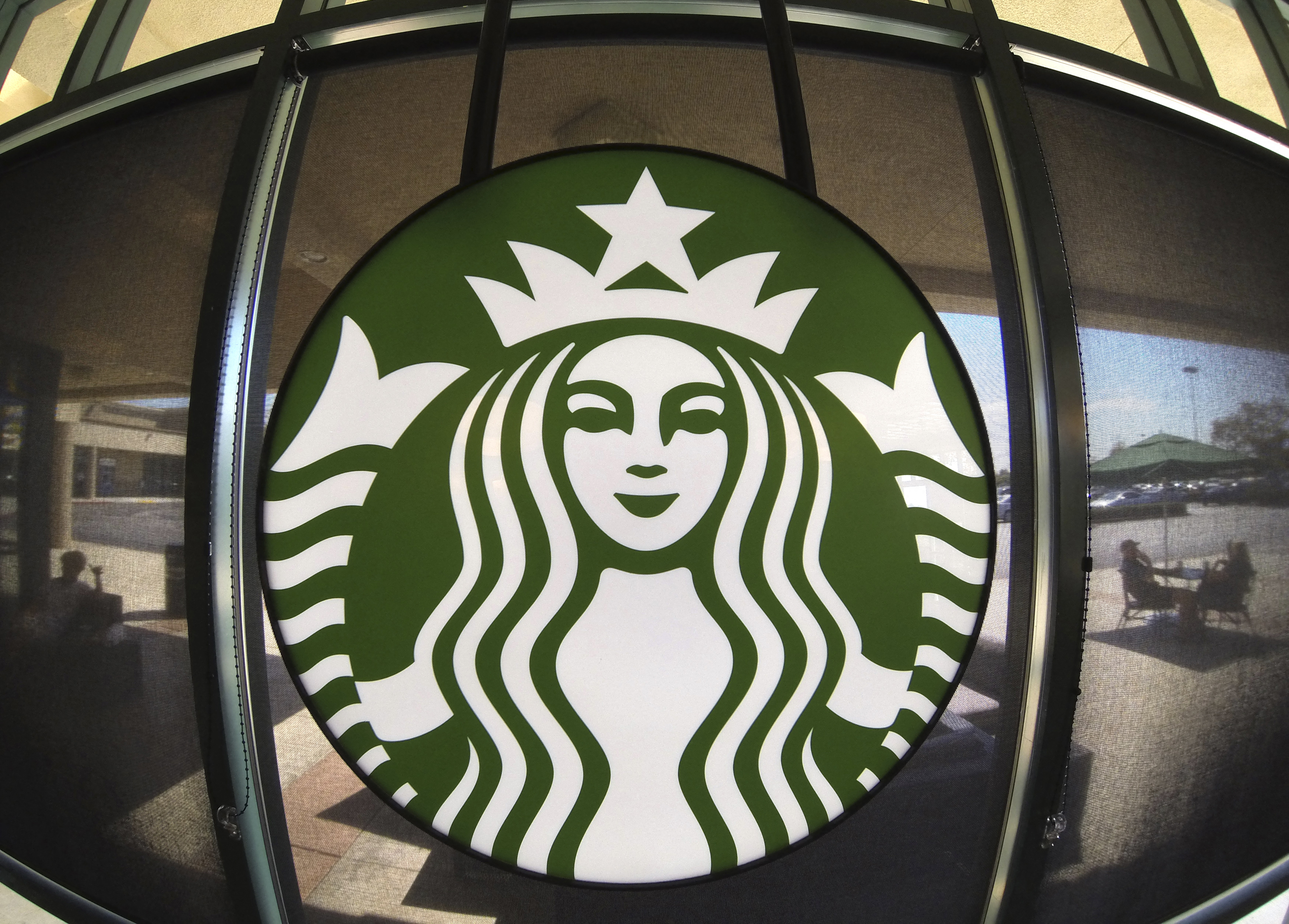 The Starbucks logo hangs on a window inside a newly designed Starbucks coffee shop in Fountain Valley, Californi
