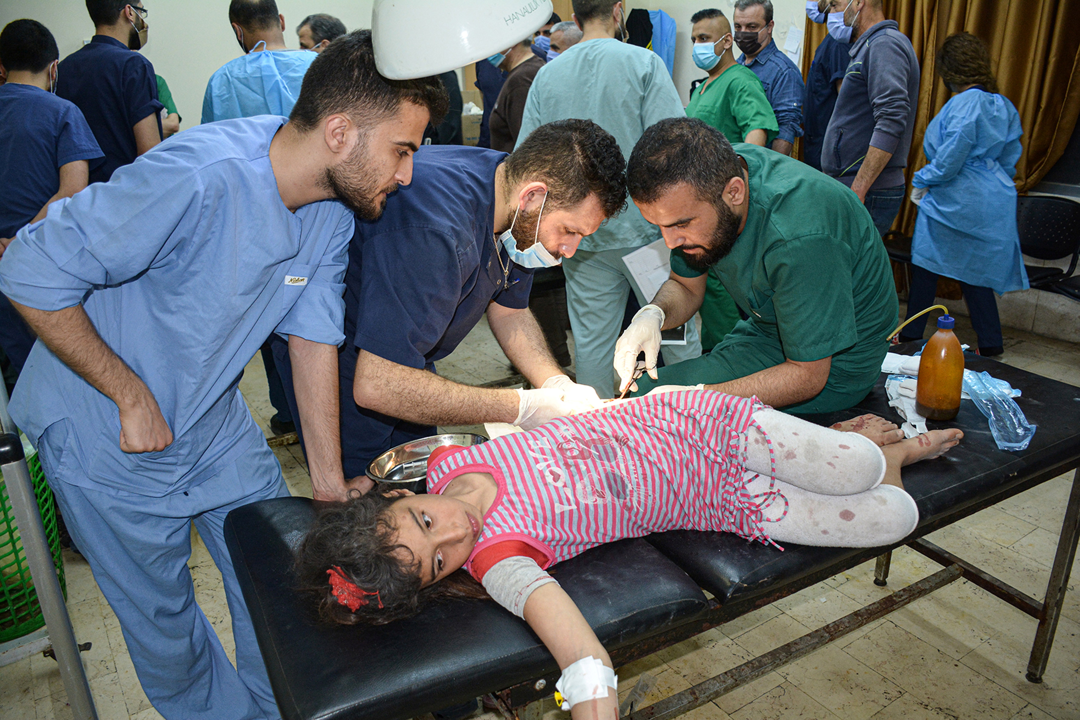 An injured girl is treated after pre-dawn raids on the Mediterranean port region of Latakia