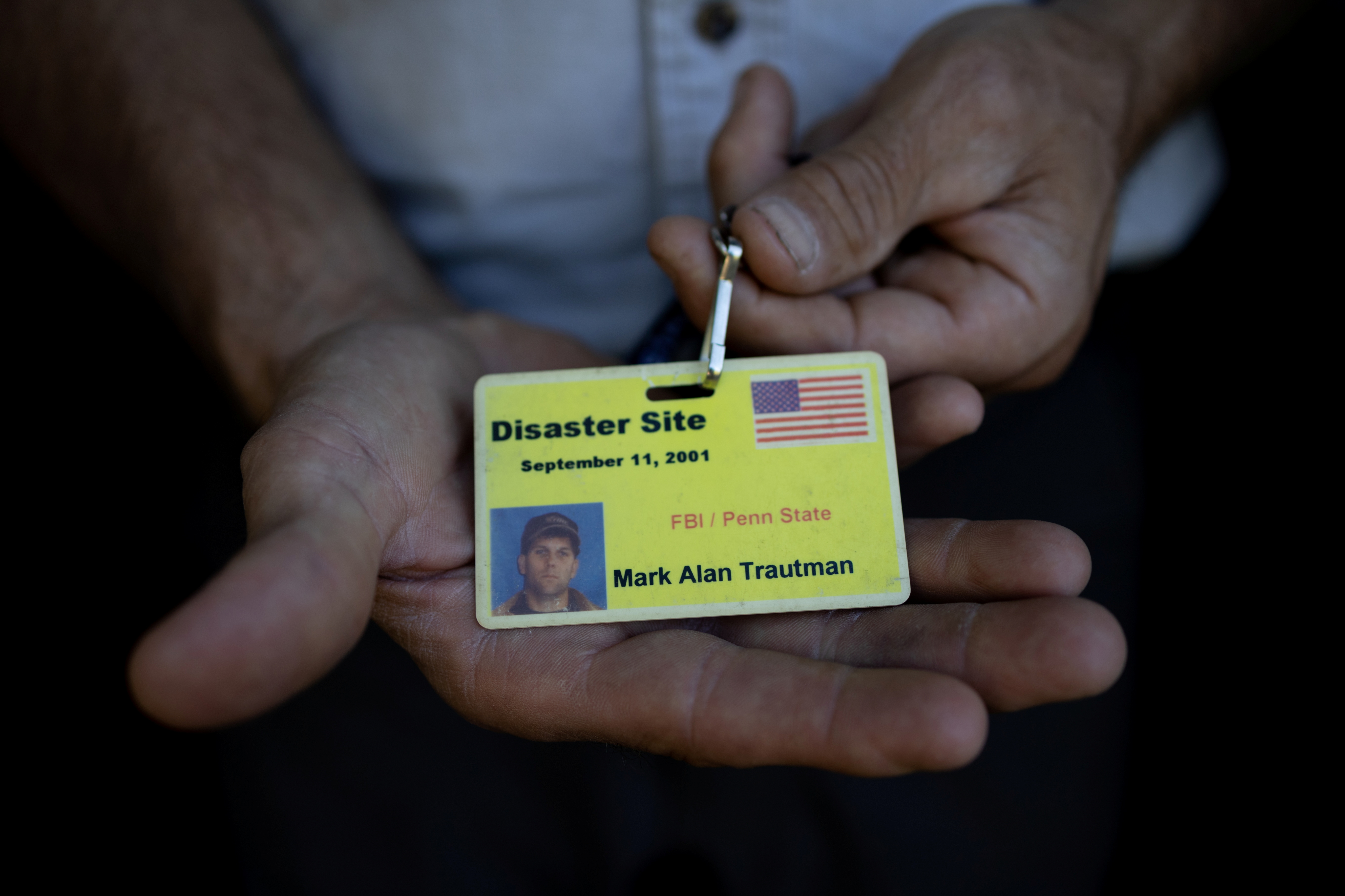 Arborist Mark Trautman holds his badge from when he was on site during 9/11, at his home in Spruce Creek, Pennsylvania. REUTERS/Hannah Beier