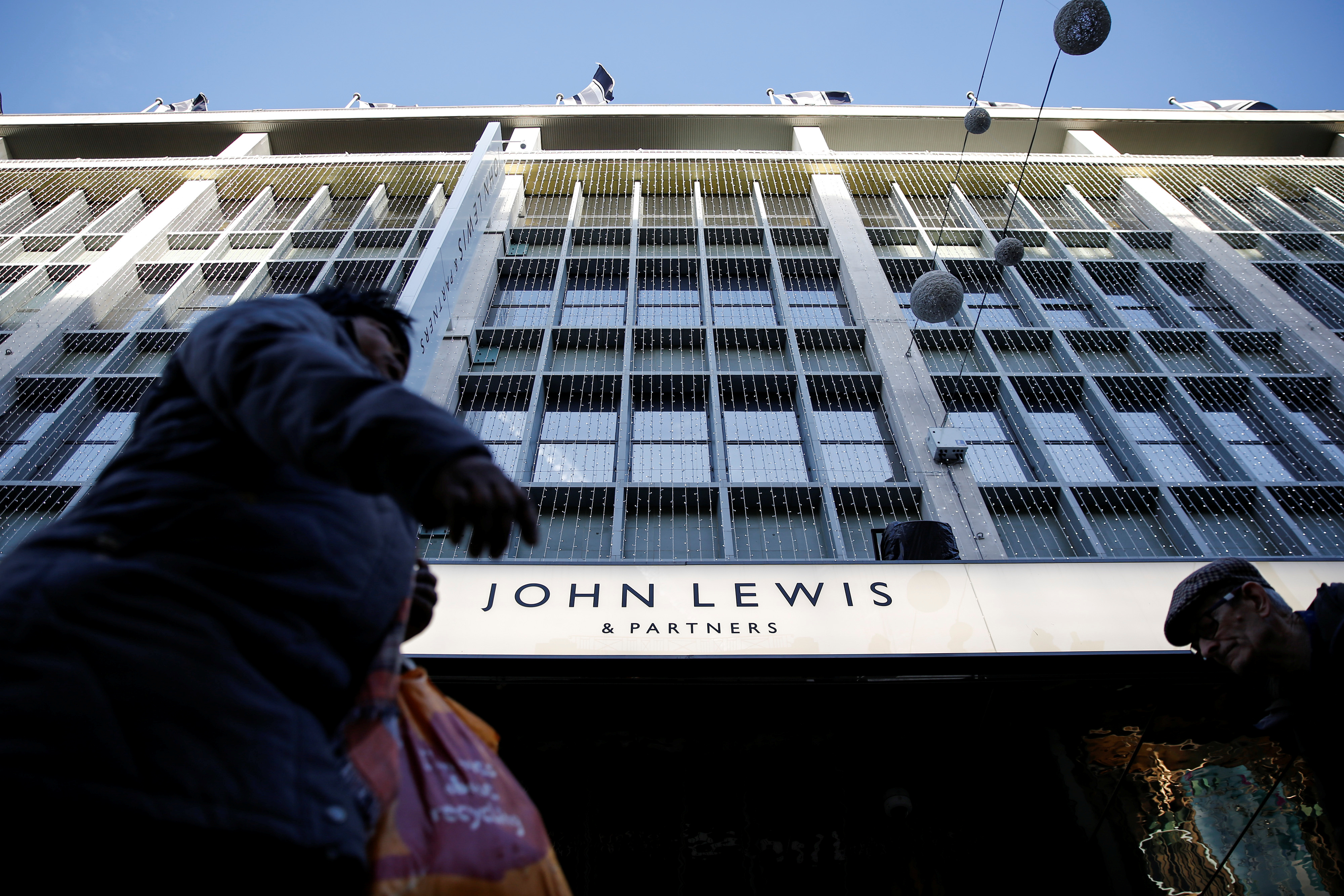 Shoppers walk past the John Lewis department store on Oxford Street in London
