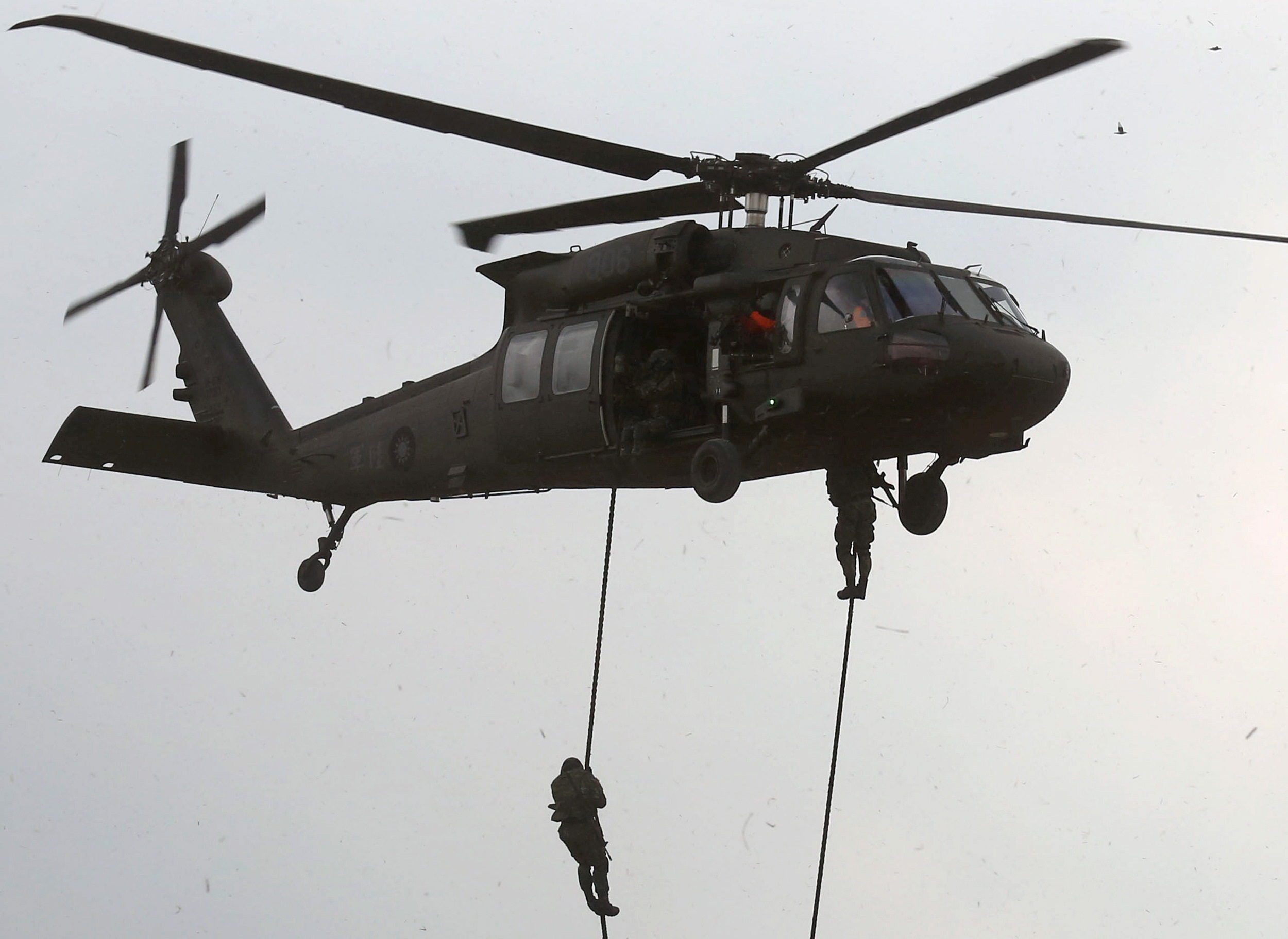 Military personnels rope down from a UH-60M Black Hawk helicopter during the annual Han Kuang military exercise in an army base in Hsinchu
