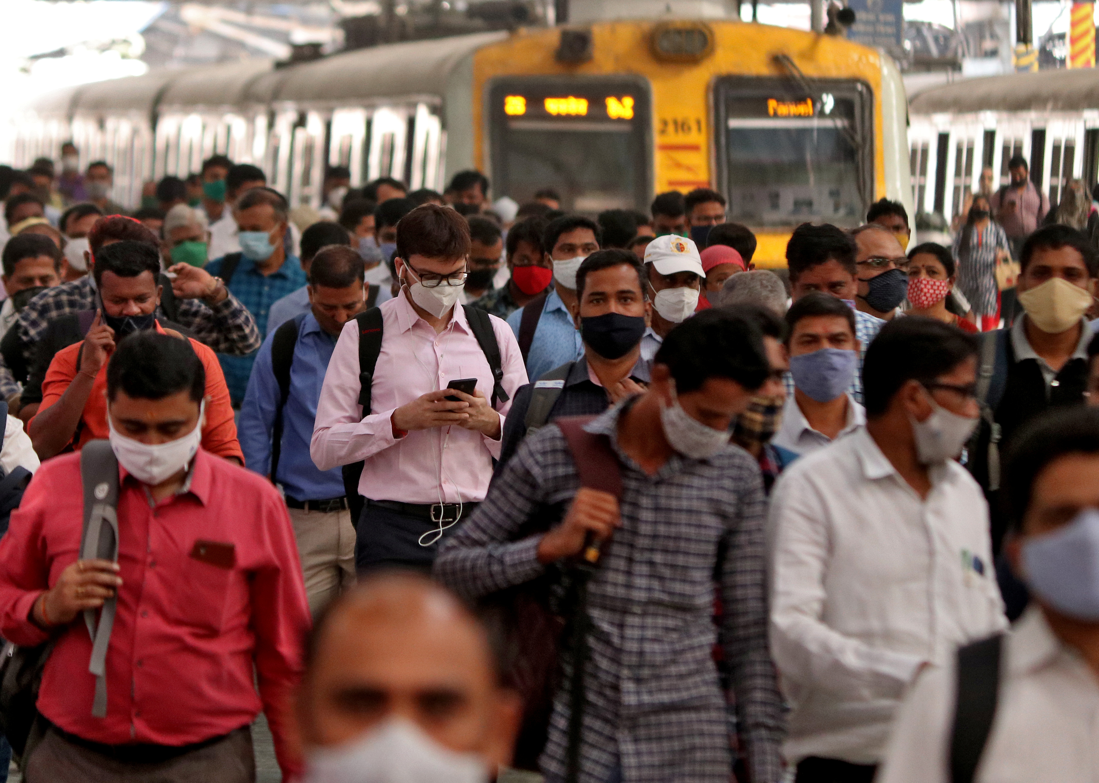 People wearing protective masks walk on a platform at the Chhatrapati Shivaji Terminus railway station, amidst the spread of the coronavirus disease (COVID-19), in Mumbai, India, March 16, 2021. REUTERS/Niharika Kulkarni