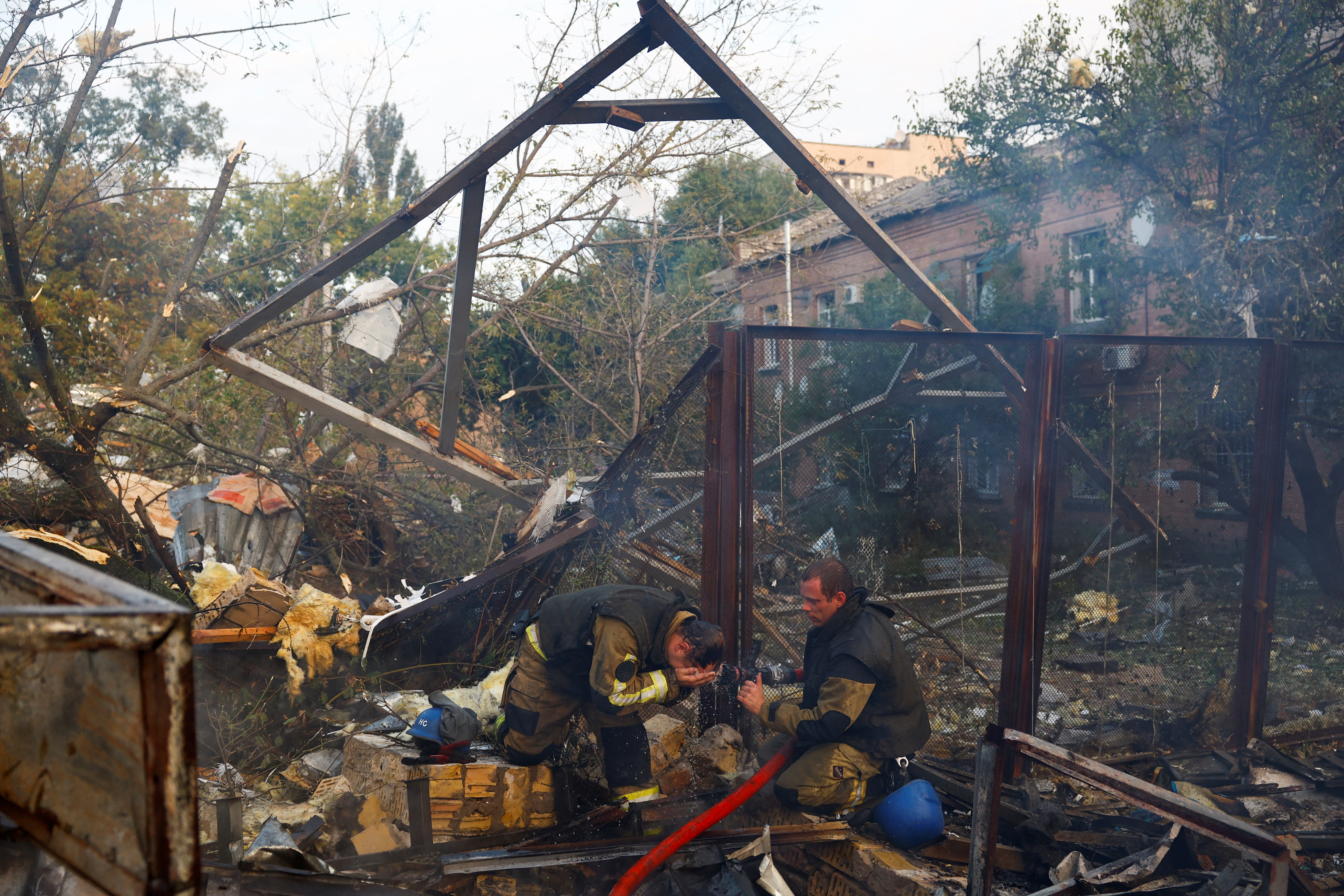 Firefighters work at a site damaged during a Russian missile strike, in Kyiv