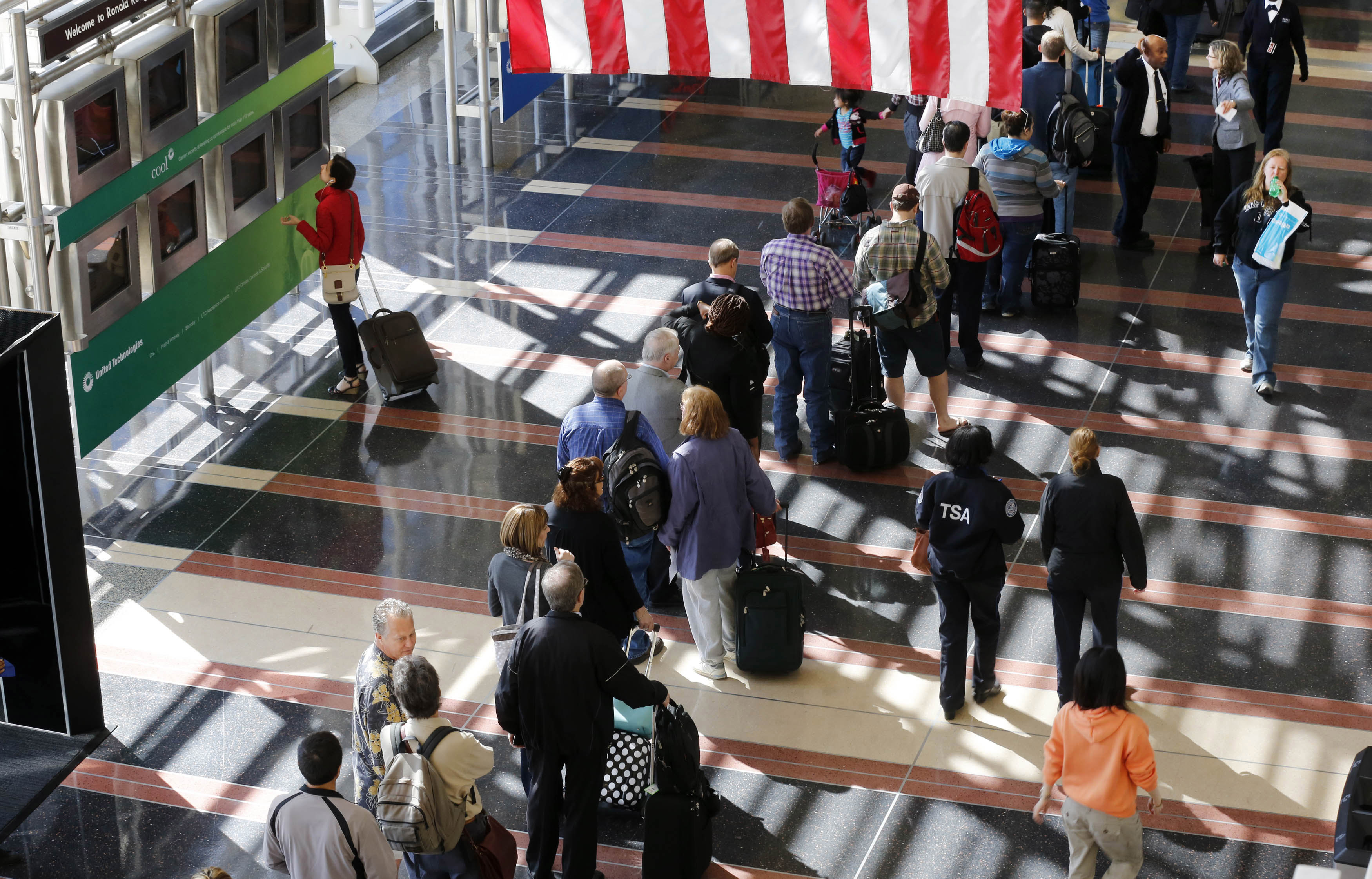 A line of passengers wait to enter the security checkpoint before boarding their aircraft at Reagan National Airport in Washington