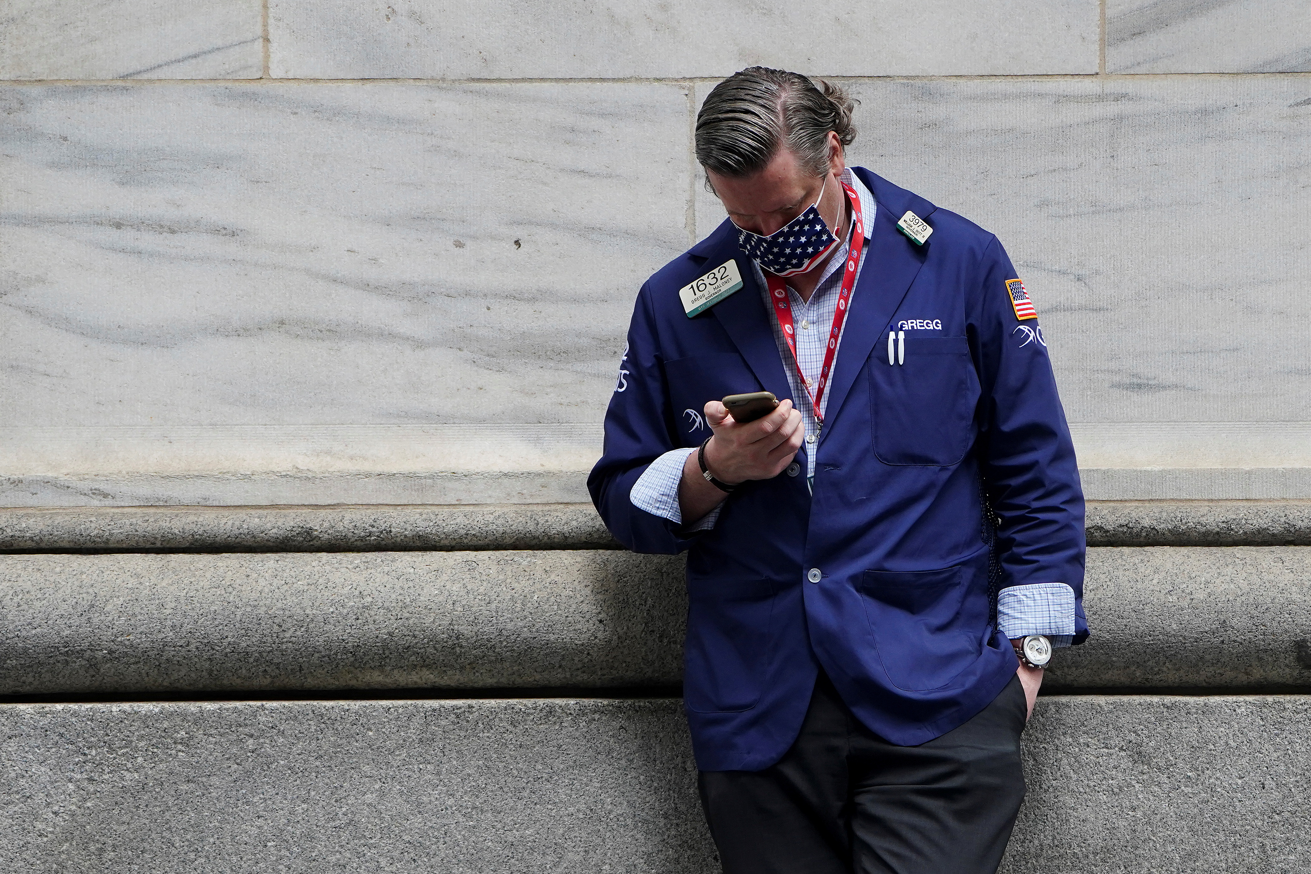 A trader takes a break outside the New York Stock Exchange in New York