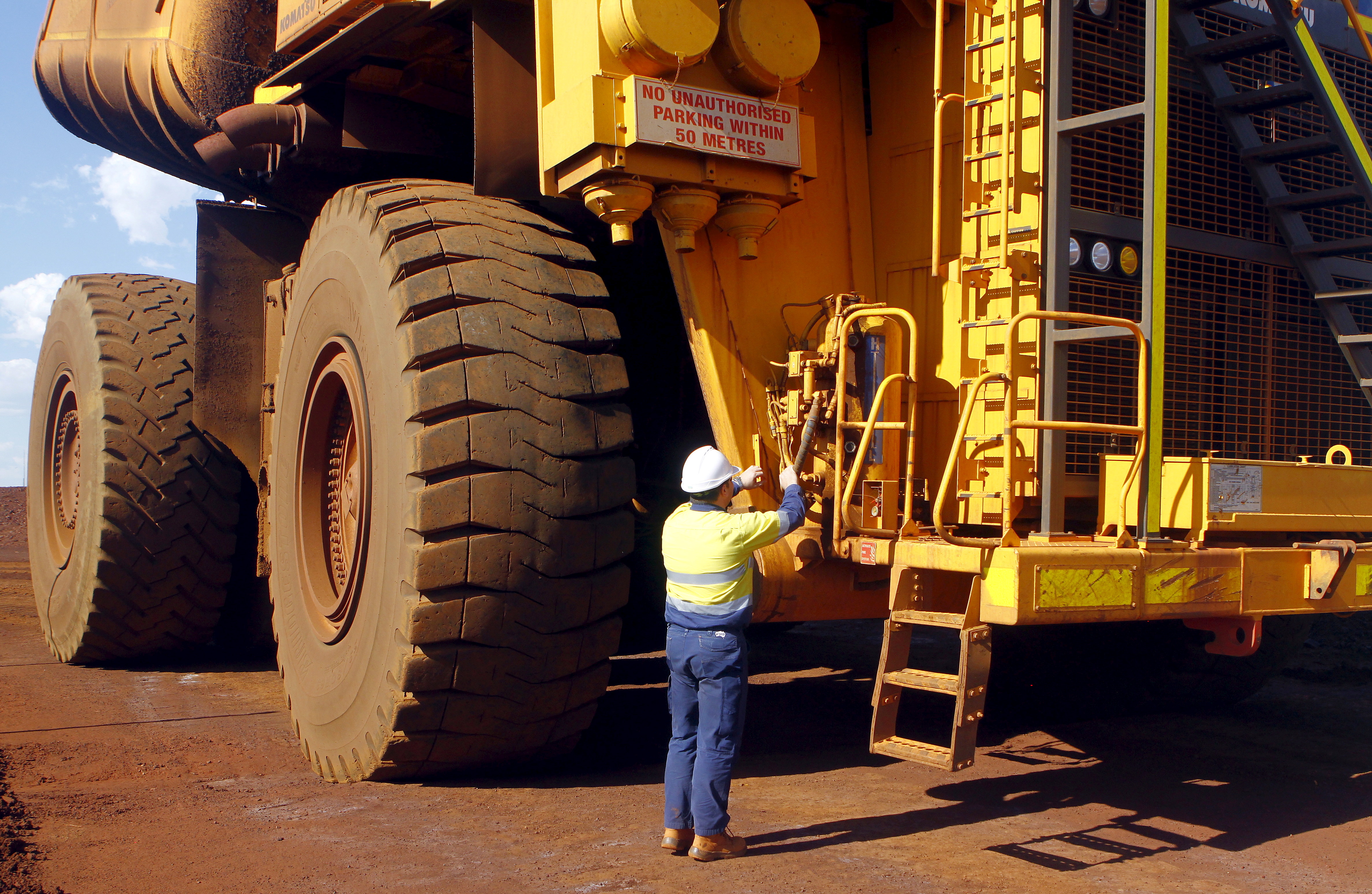 A worker checks a truck loaded with iron ore at the Fortescue Metals Group (FMG) Christmas Creek iron ore mine located south of Port Hedland in the Pilbara region of Western Australia, November 17, 2015. Picture taken November 17, 2015. REUTERS/Jim Regan