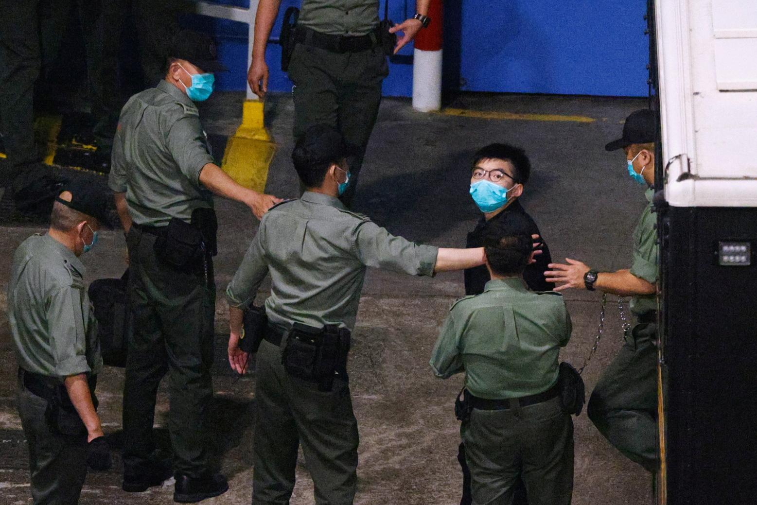 Pro-democracy activist Joshua Wong looks on upon arriving at Lai Chi Kok Reception Centre after he remained in custody over the national security law charge, in the early morning, in Hong Kong