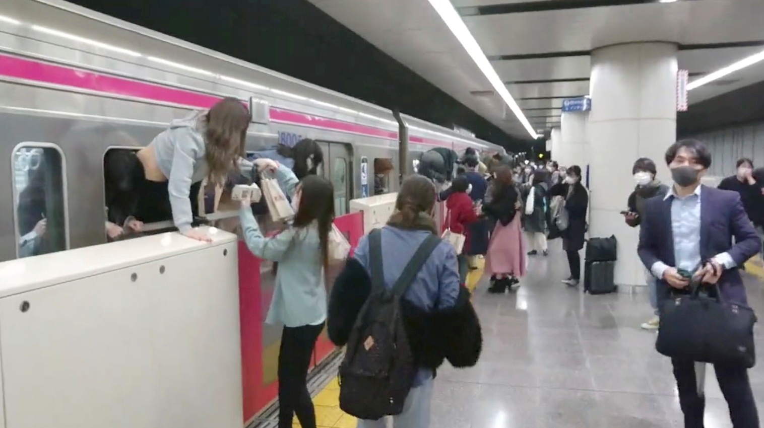 People escape through windows of a Tokyo train line following a knife, arson and acid attack, in Tokyo, Japan October 31, 2021 in this still image obtained from a social media video. TWITTER / @SIZ33/via REUTERS 