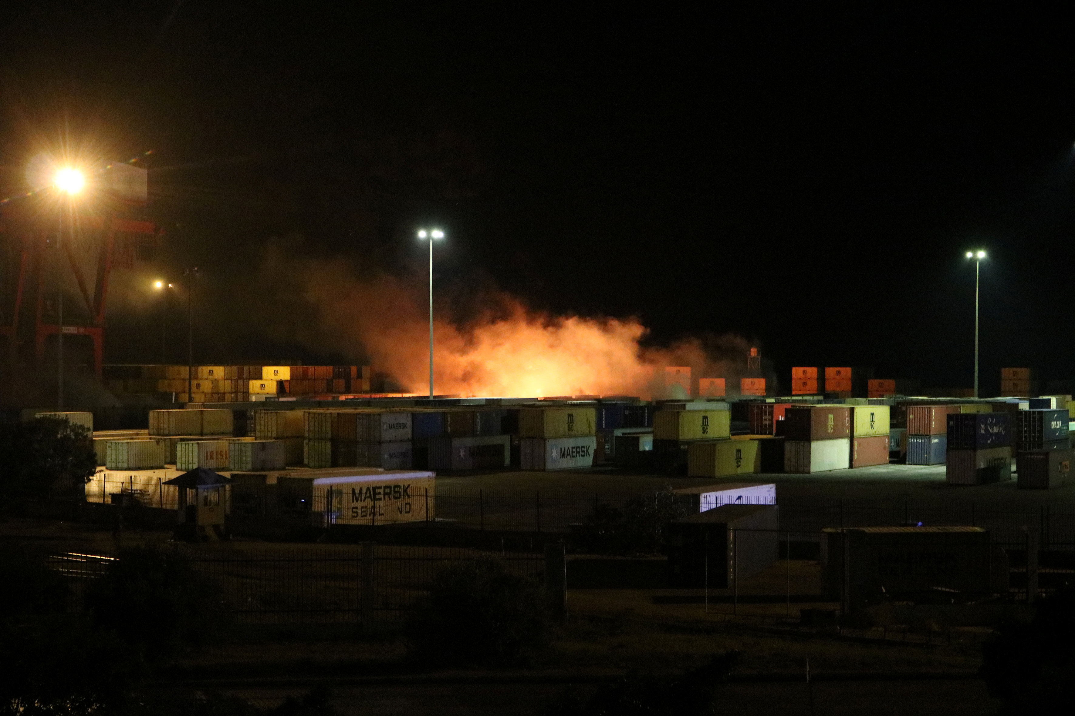 Smoke rises from a container storage area in the Syrian port of Latakia