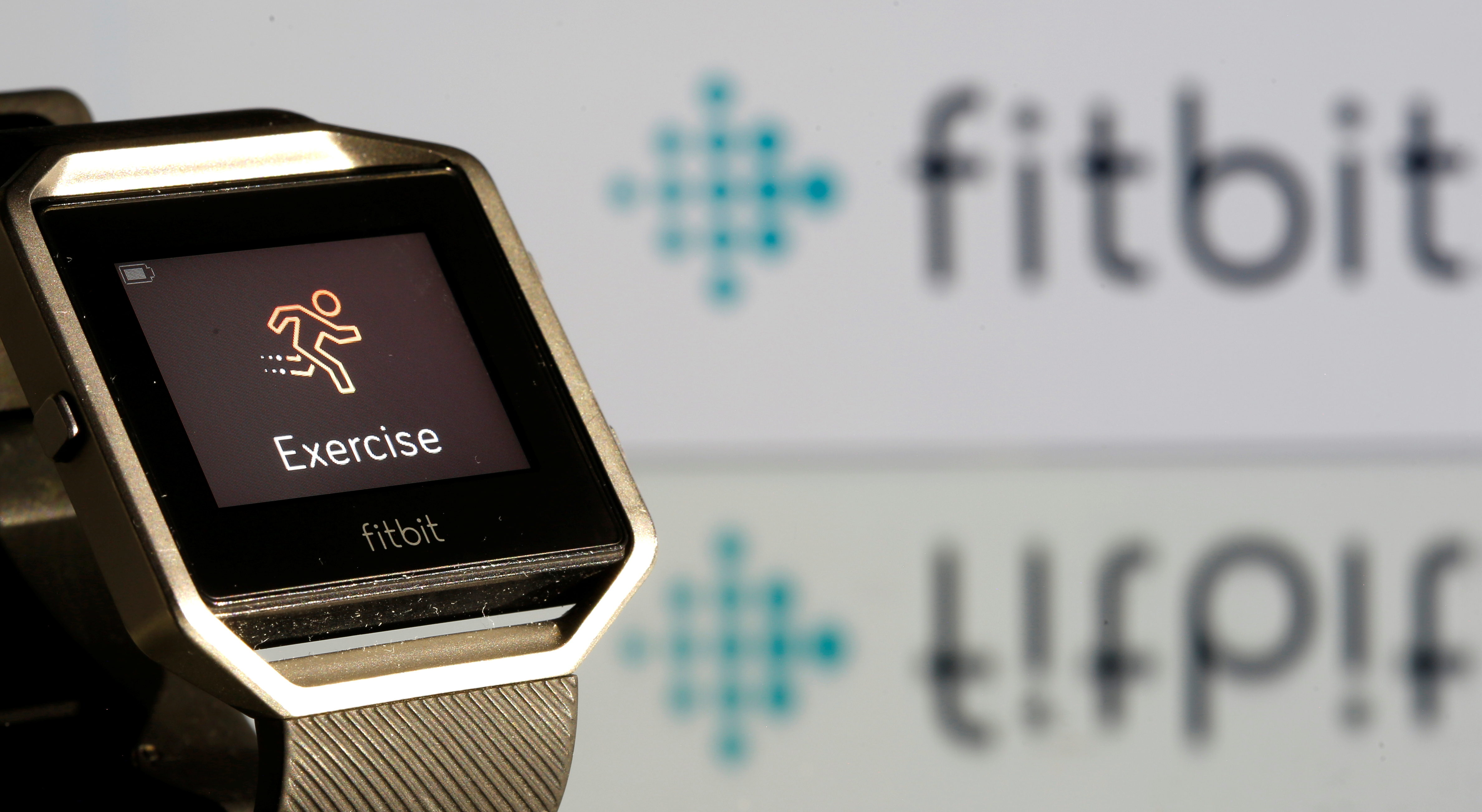 Fitbit Blaze watch is seen in front of a displayed Fitbit logo in this illustration
