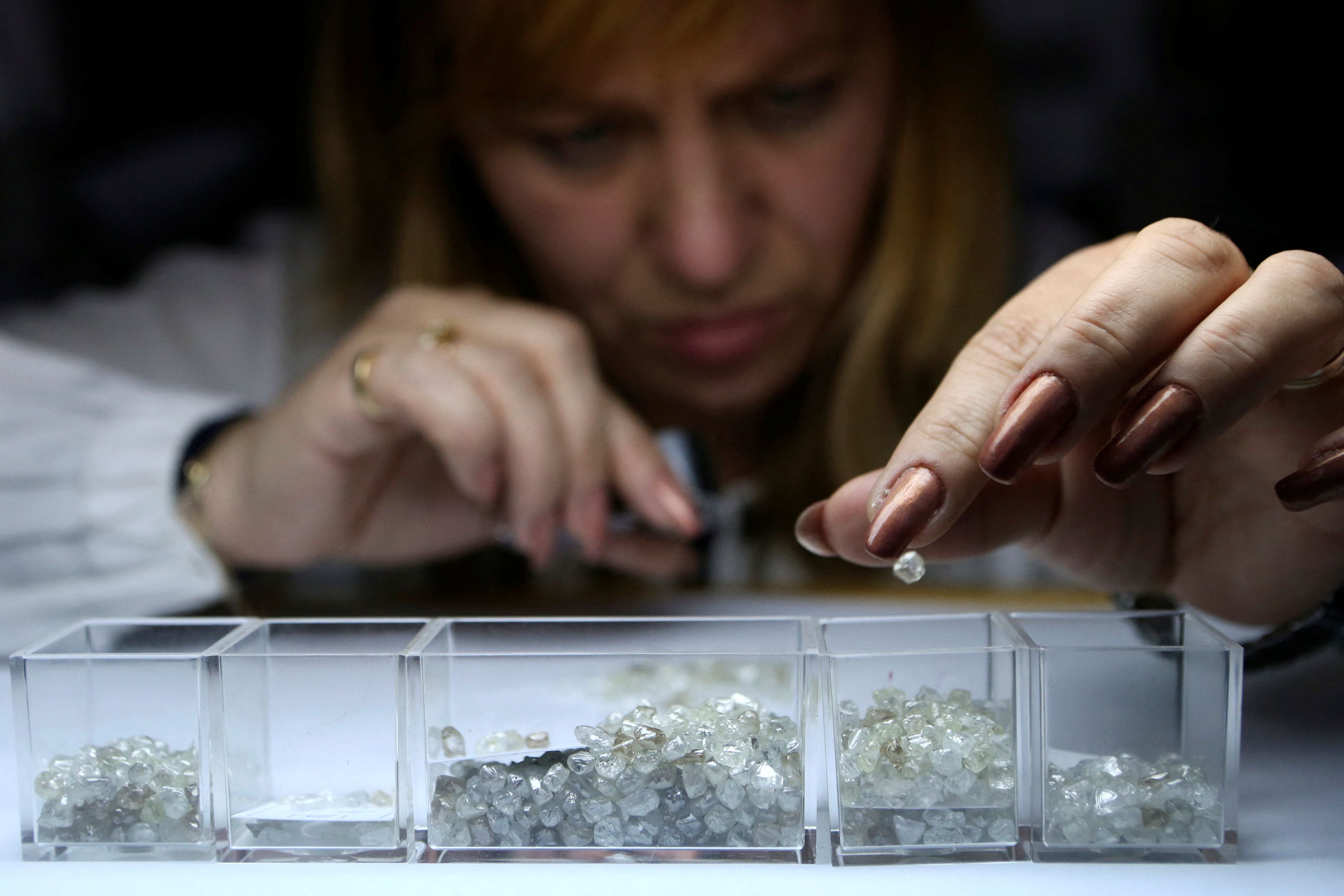 An employee sorts rough diamonds at a sorting centre, owned by Alrosa company, in Moscow