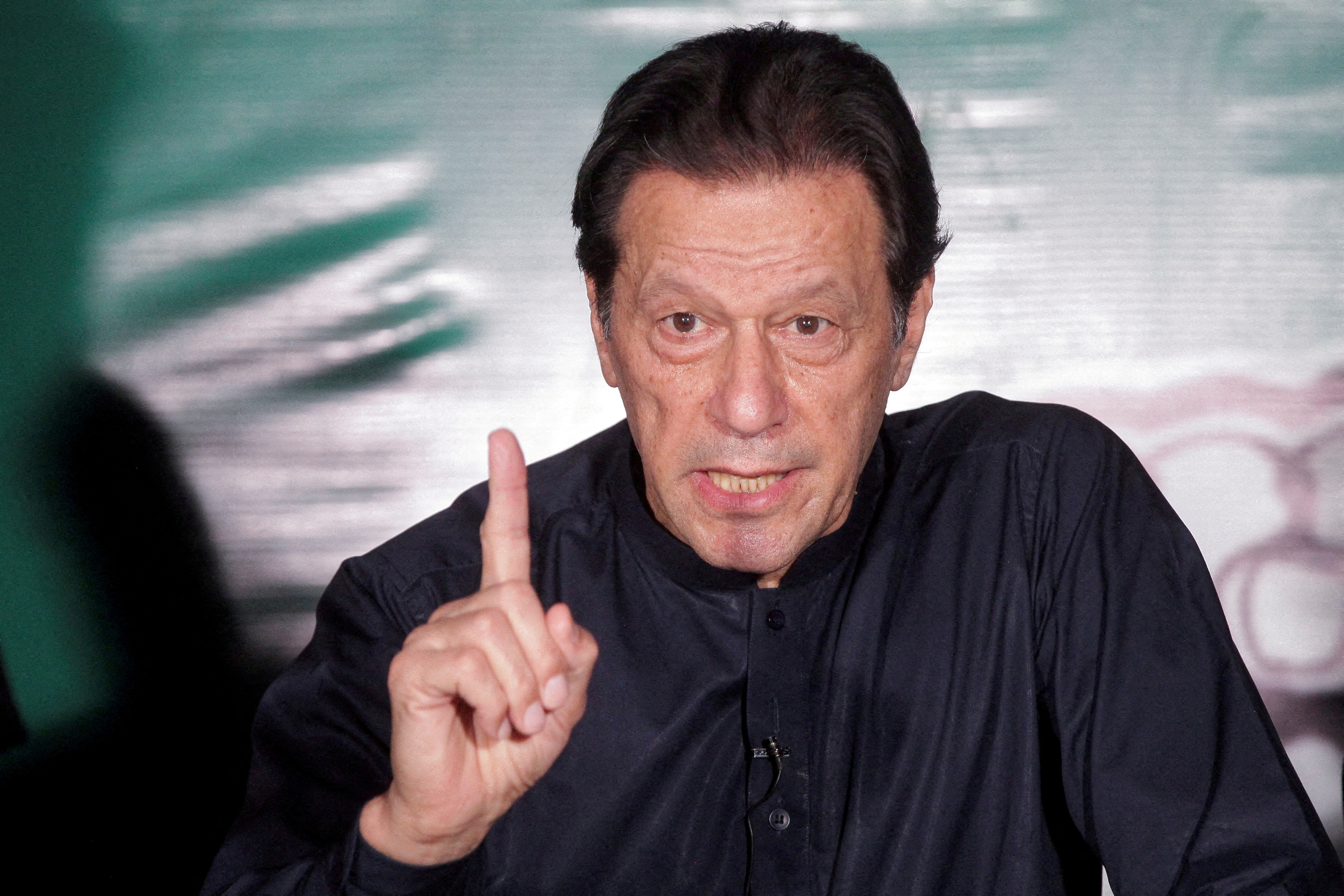 Pakistan's former Prime Minister Imran Khan gestures as he speaks to the members of the media at his residence in Lahore
