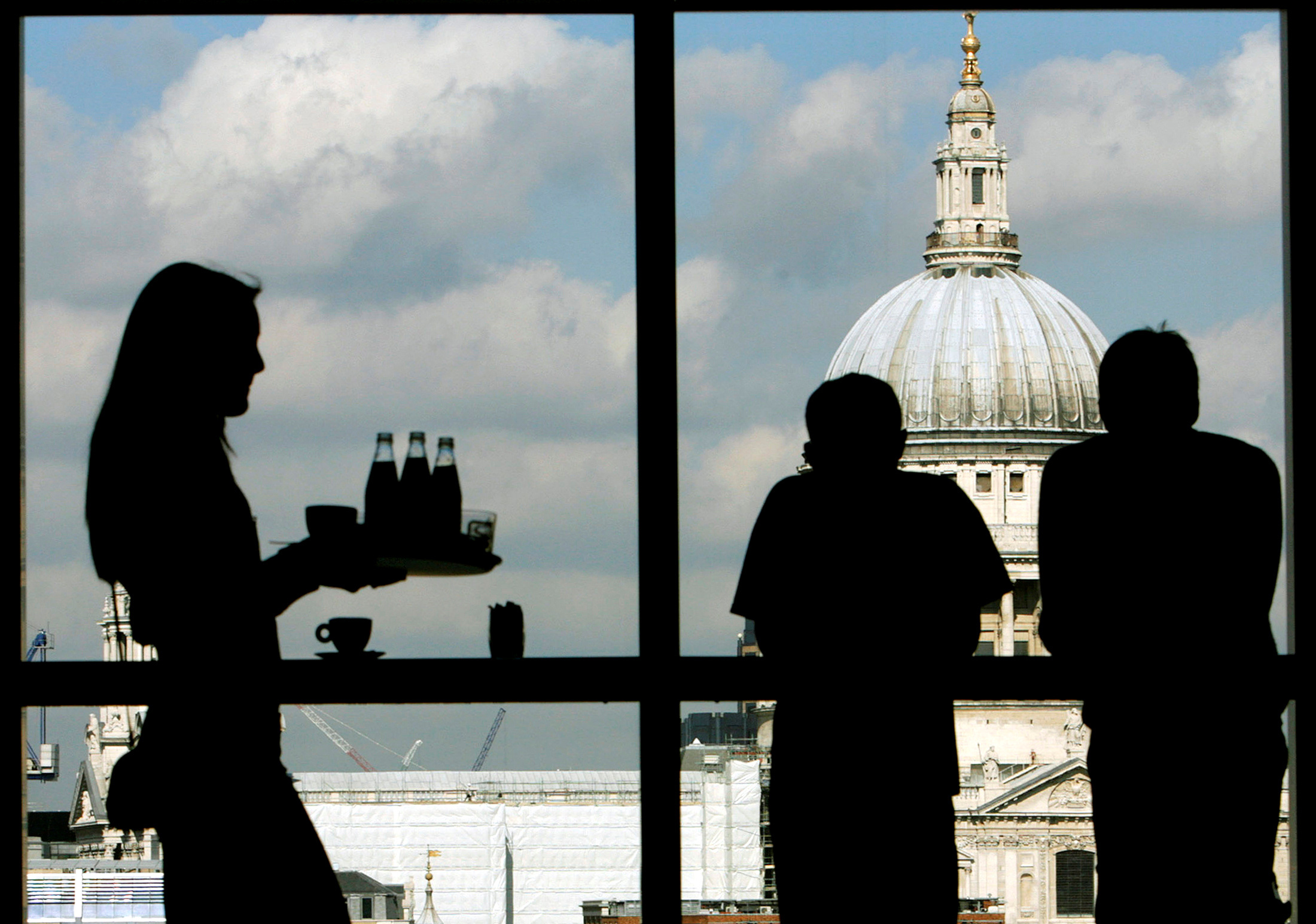 Visitors admire St. Paul's Cathedral from the restaurant floor of the Tate Modern gallery in London